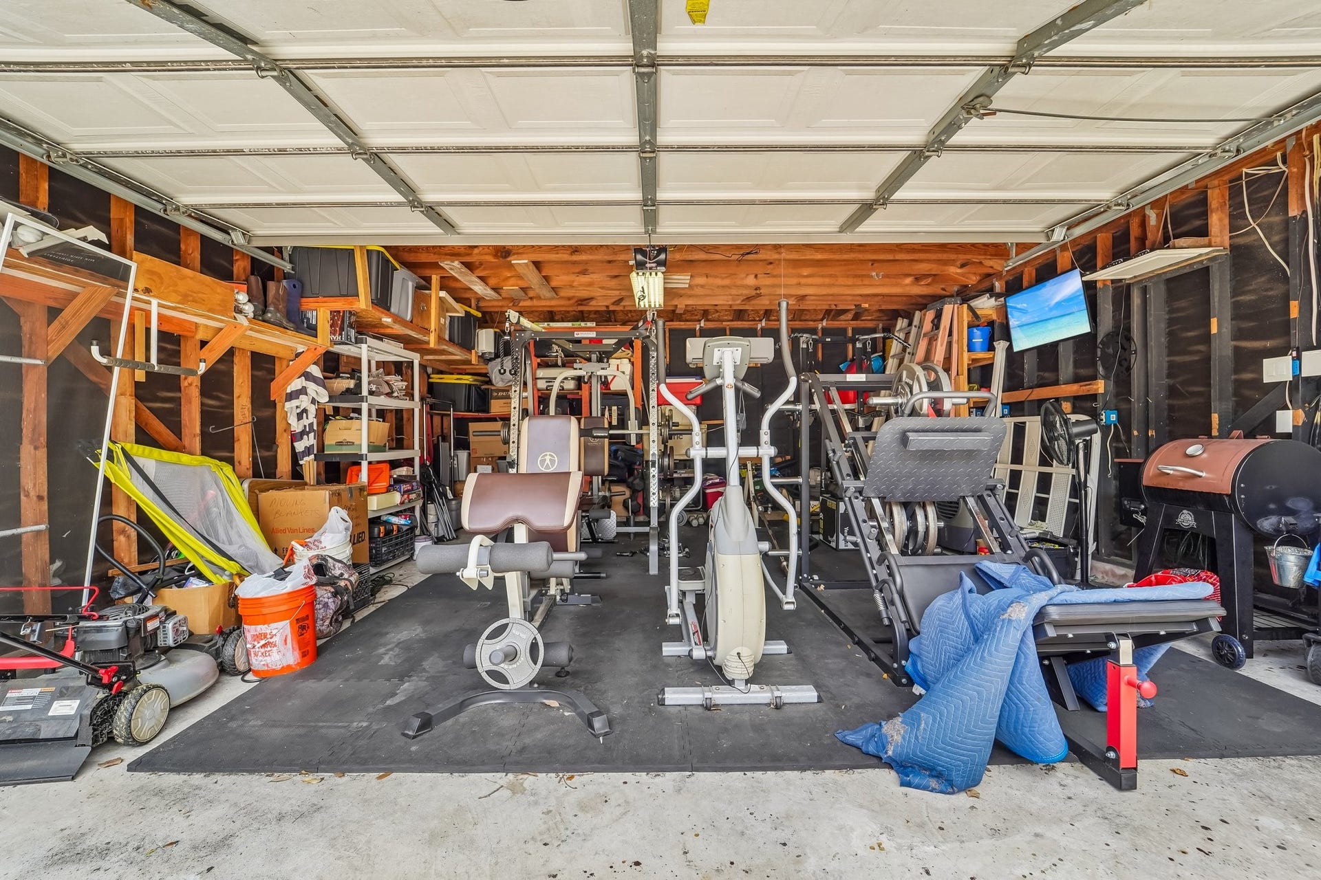 Spacious garage transformed into a versatile home gym, complete with exercise equipment and ample storage solutions, perfect for fitness enthusiasts.