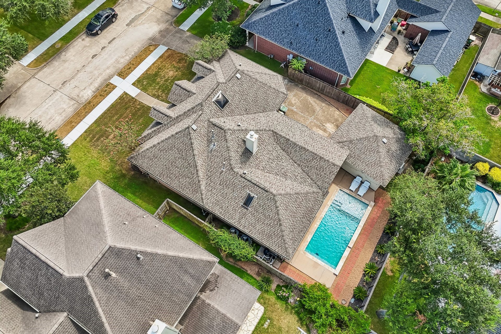 Spacious home with a private backyard oasis featuring a pristine swimming pool, ample patio space, and lush greenery, perfect for relaxation and entertaining.