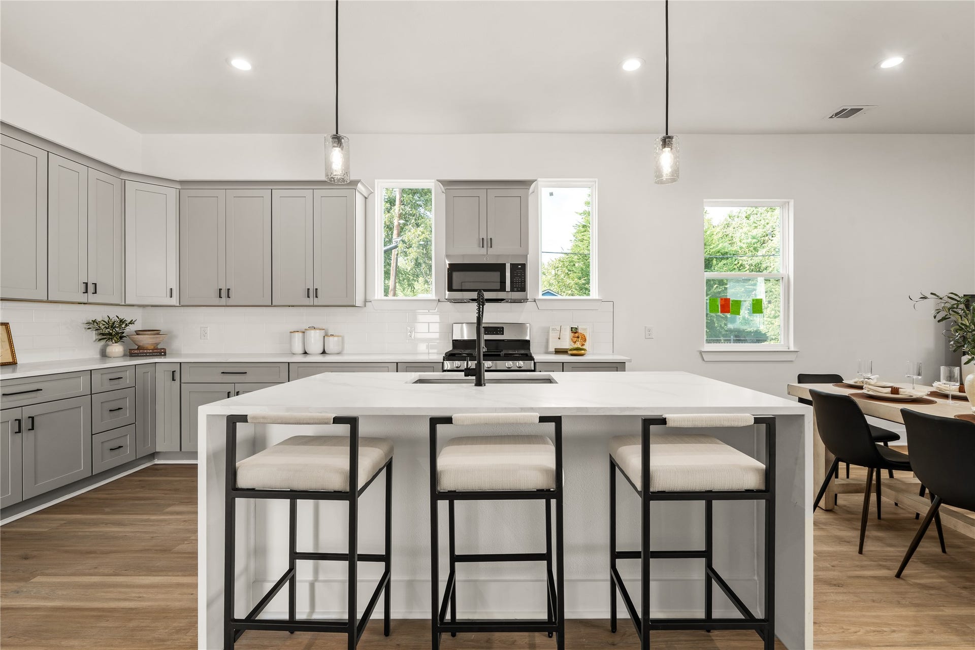 3412 Cortlandt Street, Houston, TX 77018 A pair of windows frames the range wall in balance, while the island's integrated sink and matte-black
pull-down faucet keep prep work centered and connected to the rest of the room.