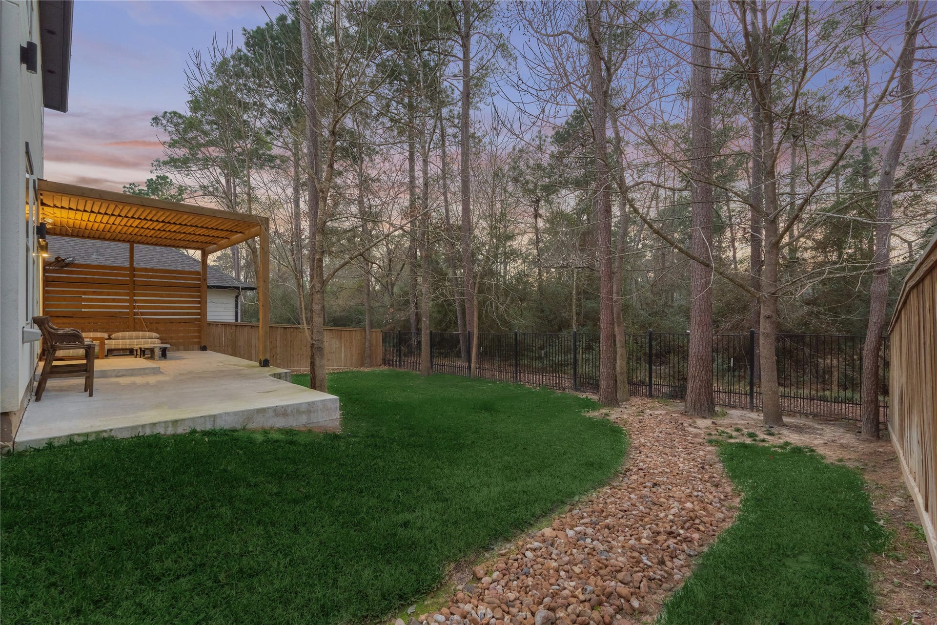 The wrought-iron fencing keeps views unobstructed, allowing you to fully enjoy nature and birdwatching in the spacious backyard and the serene wooded area beyond.