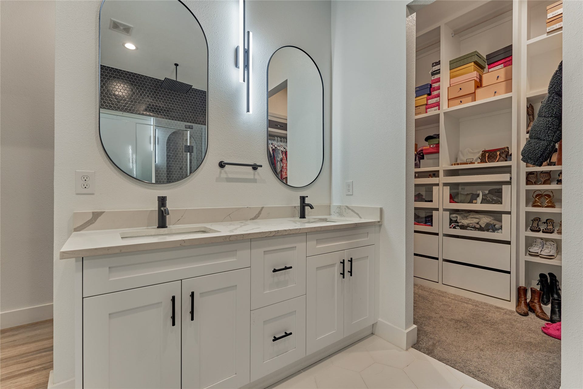 To the left of this photo are the dual vanities. To the right you get a glimpse of the dreamy primary closet which has wall-to-wall built-in 
shelving to keep everything organized.