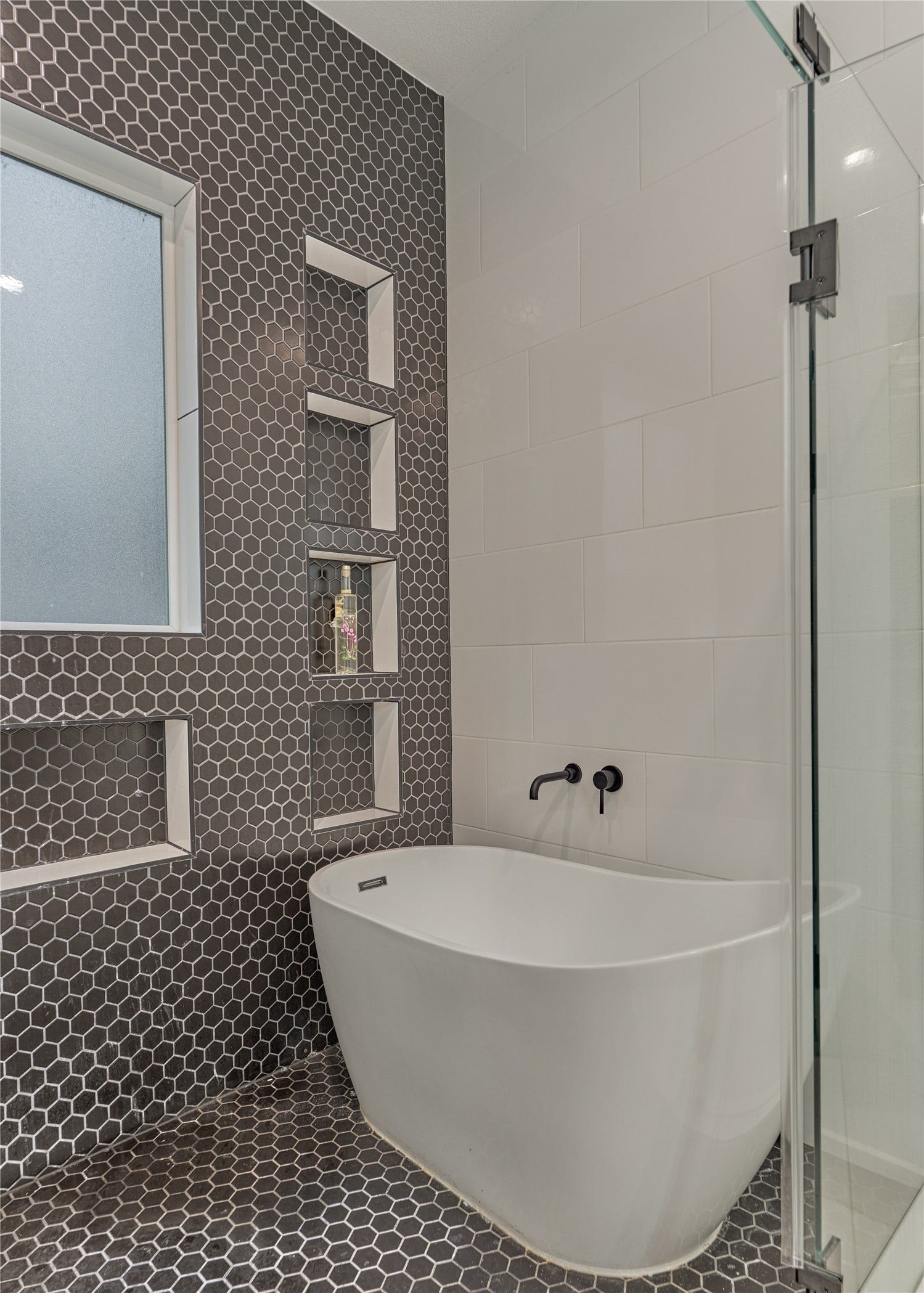 The tiled shower wall features multiple niches, keeping all your spa essentials within easy reach.