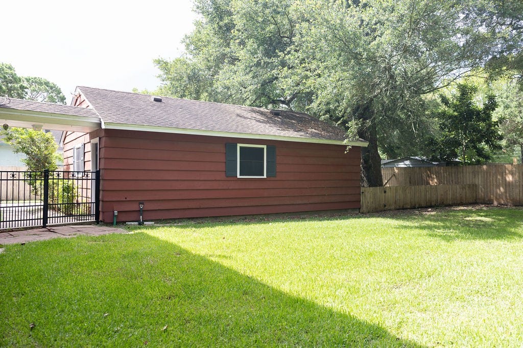 1314 Laurel Street, La Marque, TX 77568 Here's another view of the oversized garage and the expansive, fully fenced backyard. With abundant outdoor space, there's plenty of room for kids and pets to play, gardening, entertaining, or simply enjoying the privacy and peaceful surroundings.