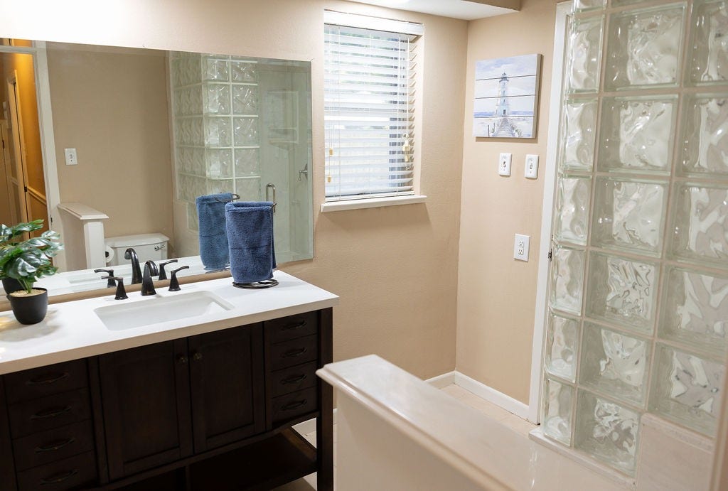 1314 Laurel Street, La Marque, TX 77568 The downstairs bathroom has been beautifully updated with a stylish vanity and a spacious walk-in shower, offering both modern design and everyday convenience for guests and family alike.