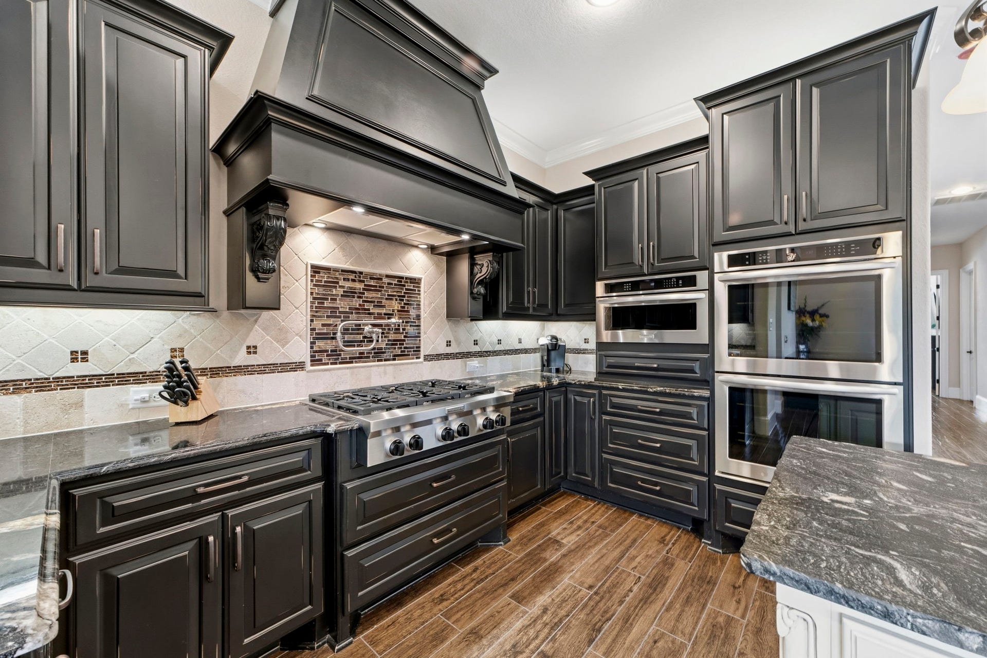 This floorplan was customized and extended to offer ample room in this Kitchen and Dining area. Luxurious leathered granite, upgraded appliances and beautiful custom cabinetry give this Kitchen the wow factor!