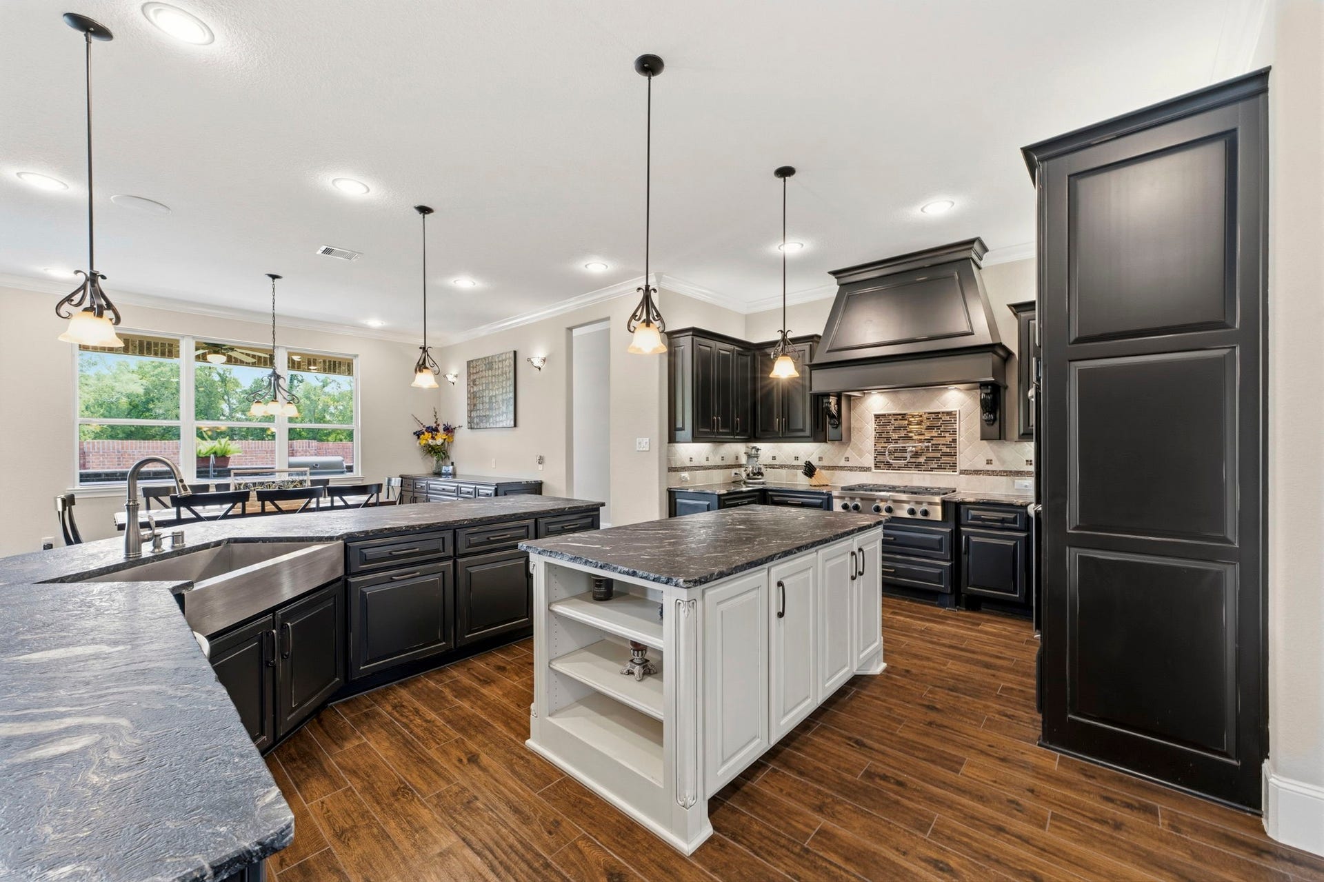 This floorplan was customized and extended to offer ample room in this Kitchen and Dining area. Luxurious leathered granite, upgraded appliances and beautiful custom cabinetry give this Kitchen the wow factor!