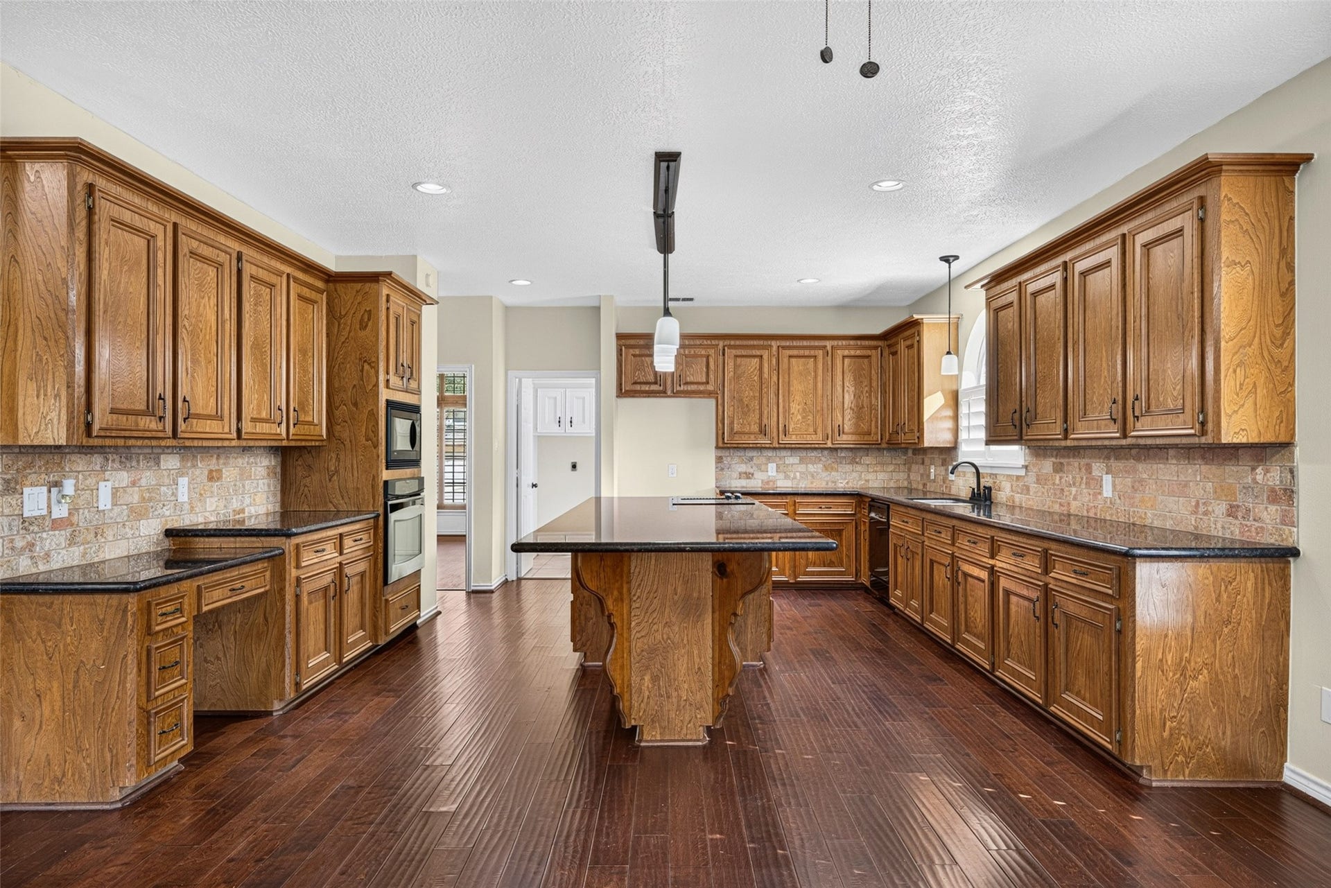 6206 Willow Pine Drive, Spring, TX 77379 The spacious kitchen features rich wood cabinetry, granite countertops, and an expansive island.