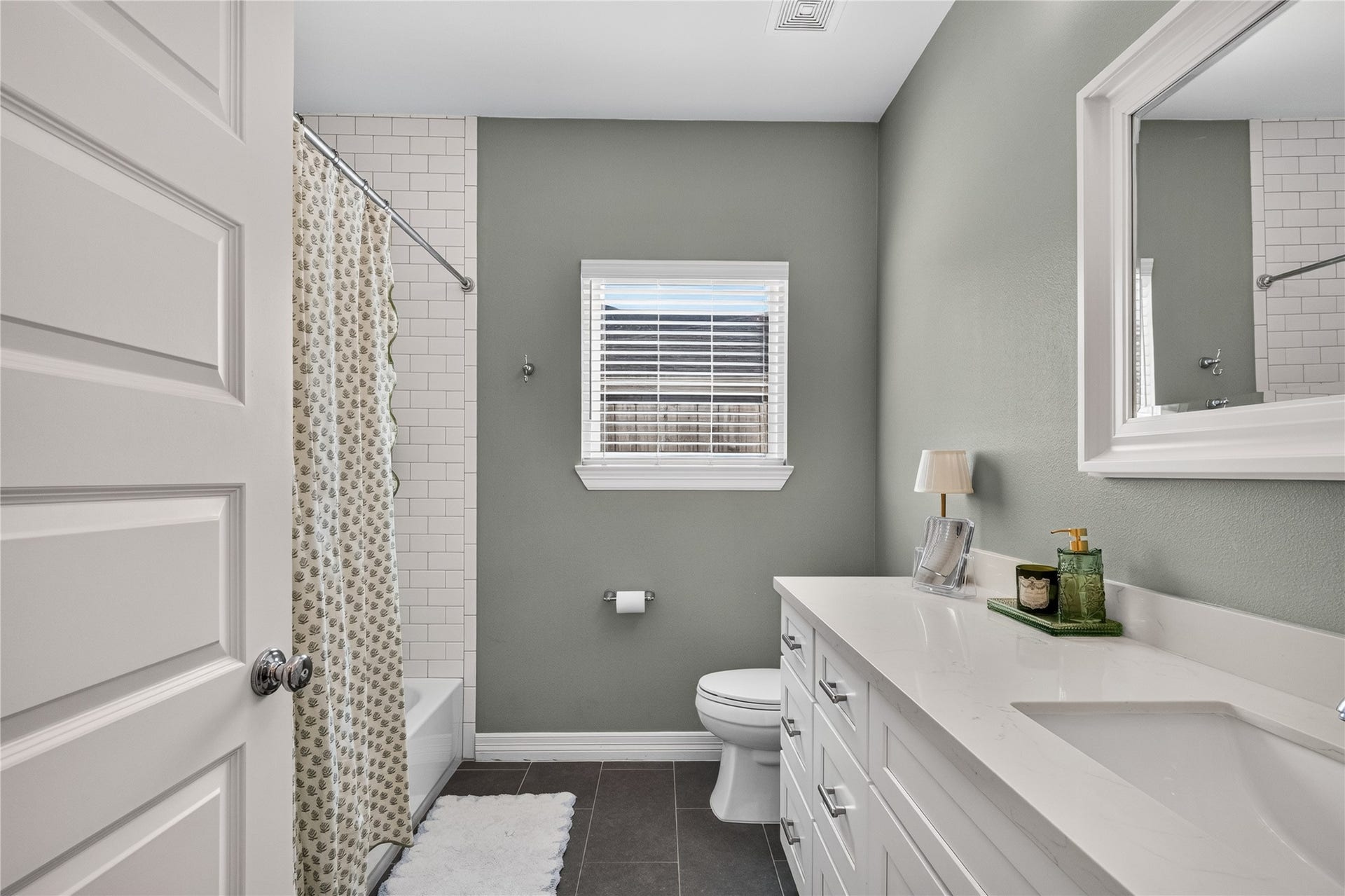 Bright and modern bathroom featuring a sleek vanity, neutral tones, and a classic subway tile tub/shower.