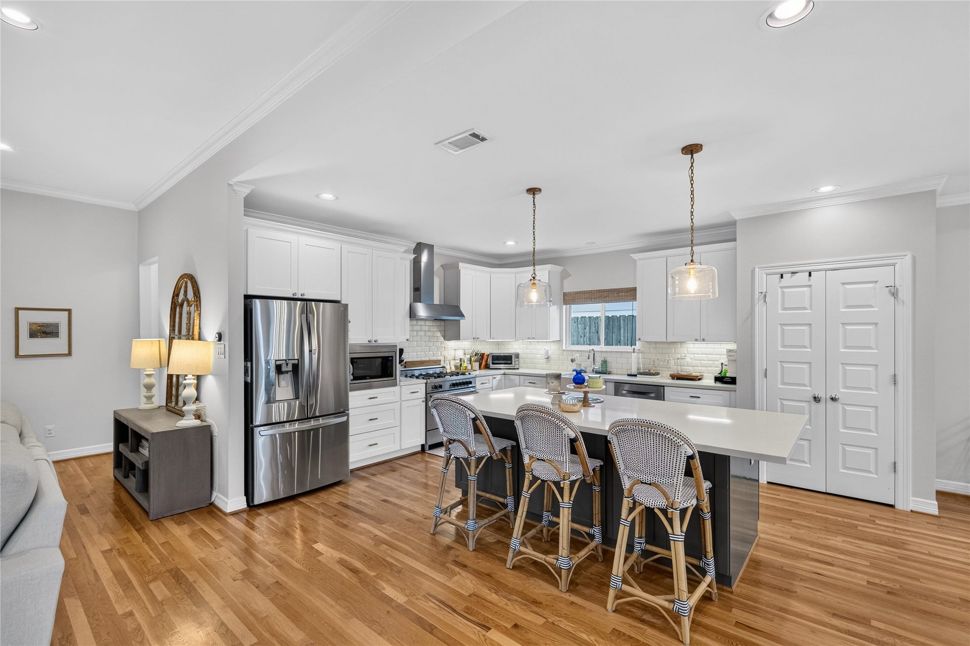 Bright and inviting kitchen with modern appliances, a spacious island with seating, and elegant pendant lighting, perfect for entertaining.