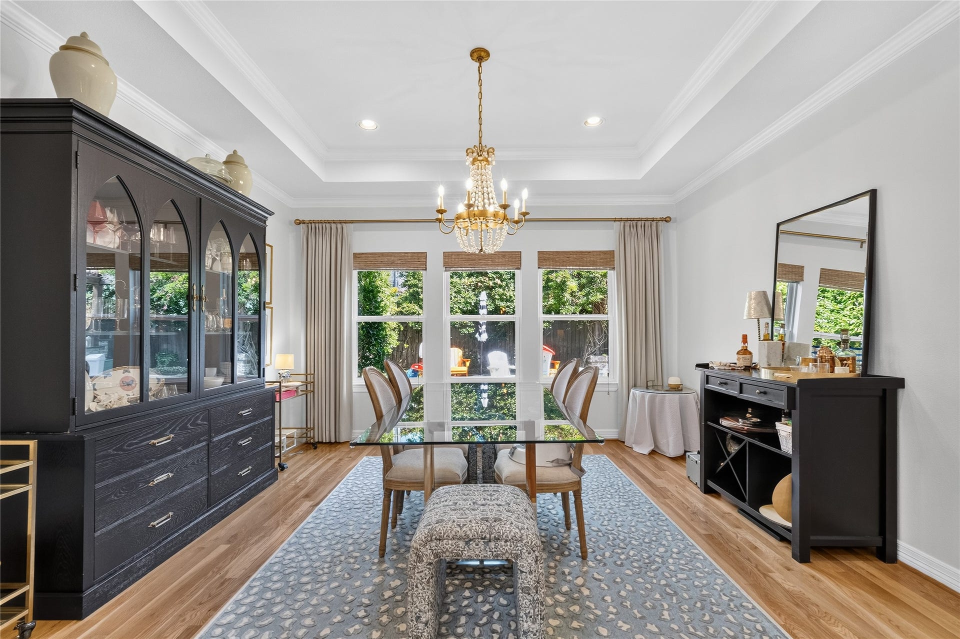 Elegant dining room featuring a stylish, chic chandelier and large windows offering plenty of natural light.