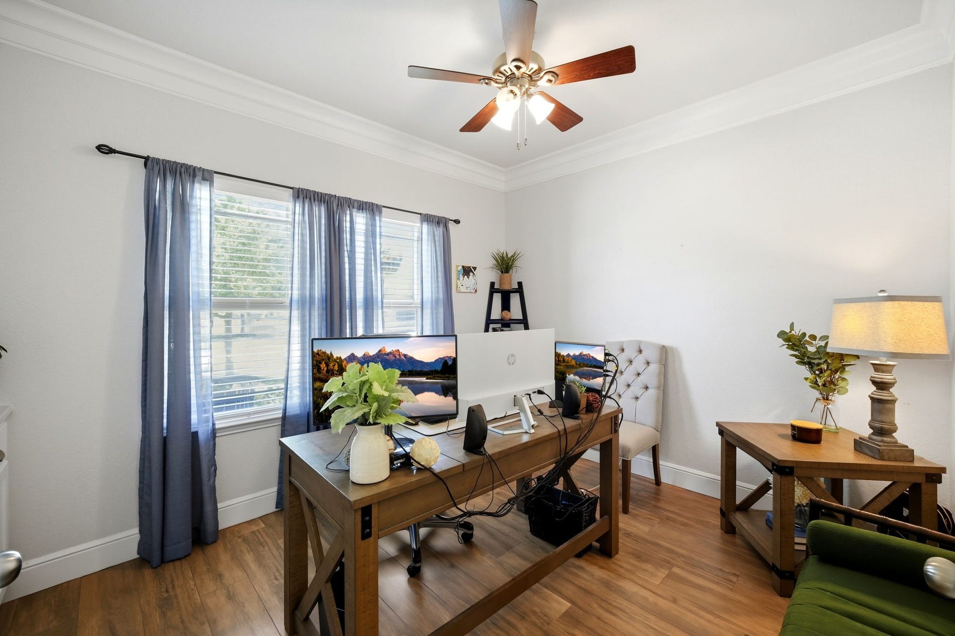 21639 Lexor Drive, Porter, TX 77365 Bright and inviting home office featuring large windows, warm flooring, and a stylish ceiling fan.