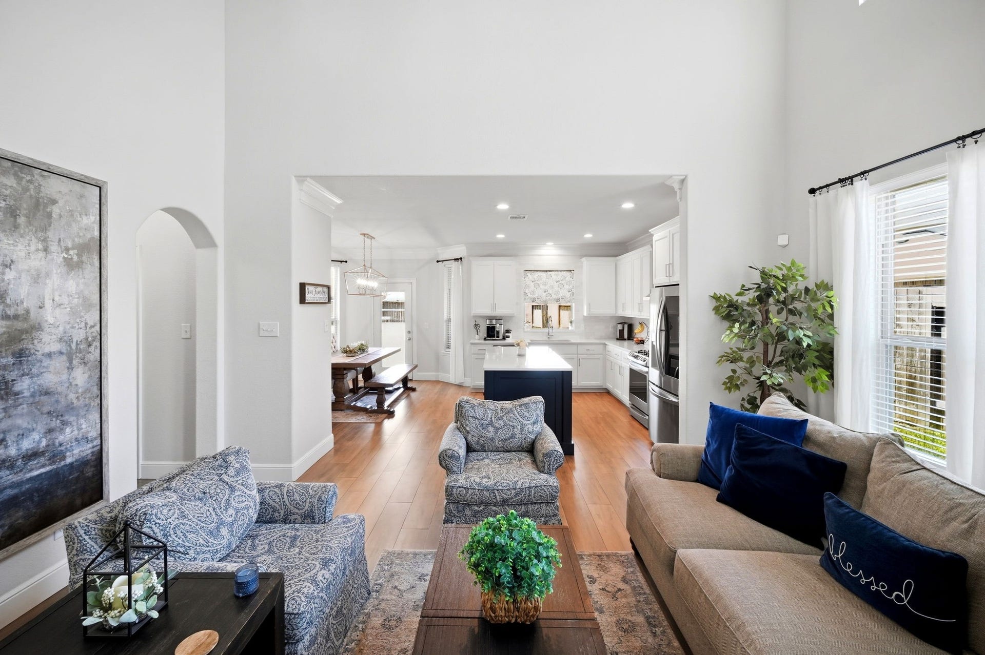 21639 Lexor Drive, Porter, TX 77365 Bright and inviting living area with high ceilings, featuring a seamless flow into a modern kitchen and dining space. Ample natural light create a warm atmosphere perfect for relaxation and entertaining.