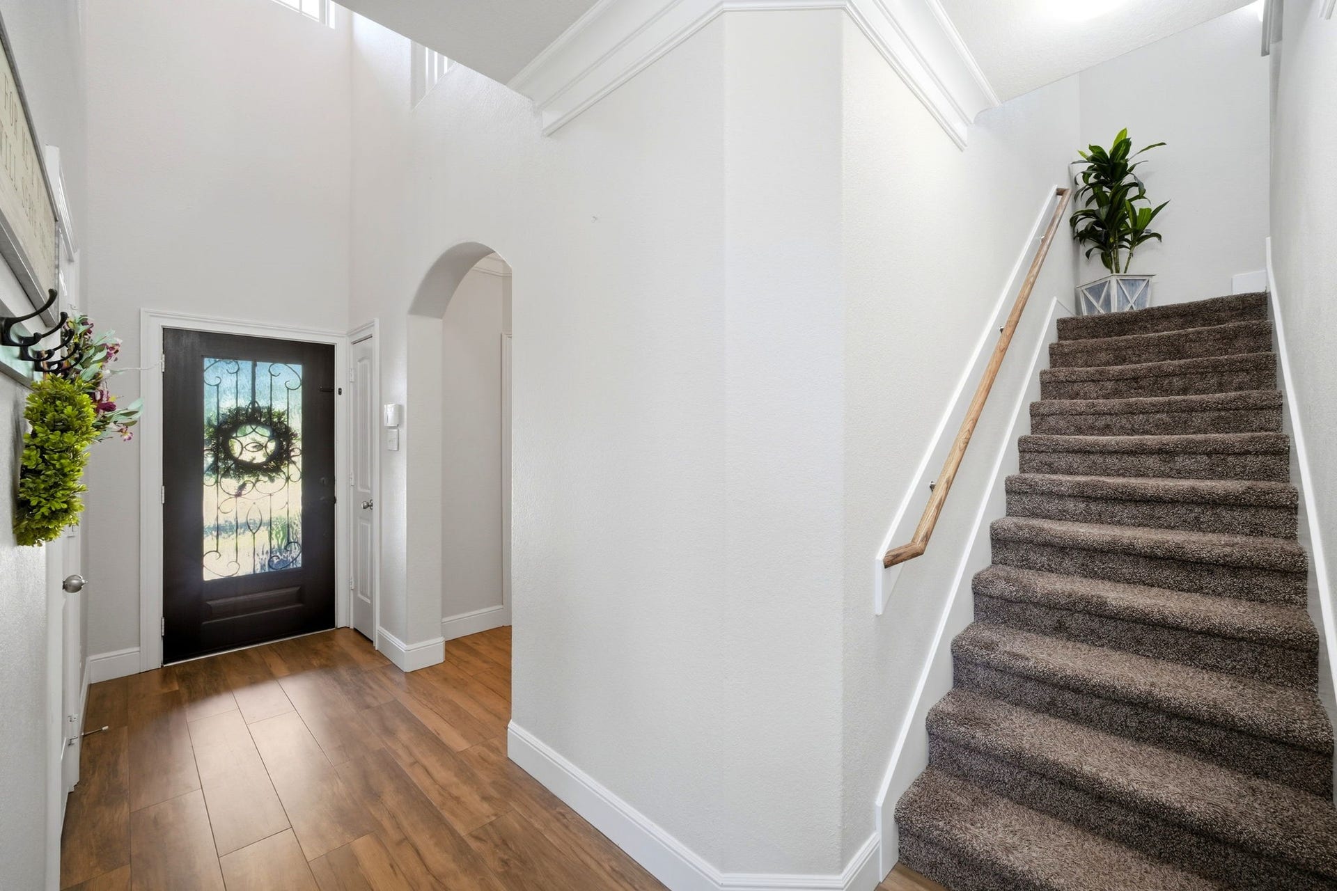 21639 Lexor Drive, Porter, TX 77365 Bright and welcoming entryway with elegant flooring and a beautifully designed front door, leading to a carpeted staircase and charming archway.