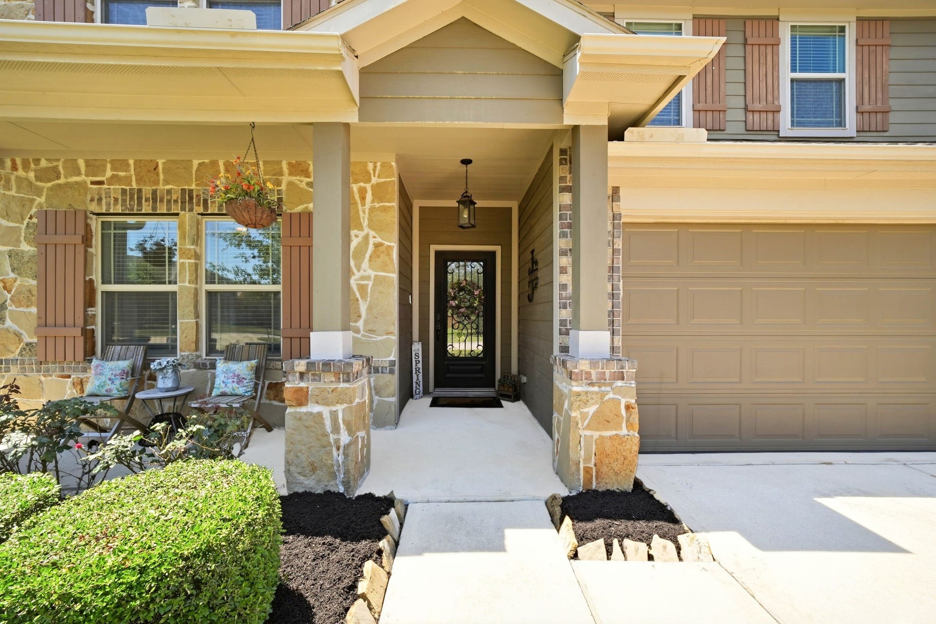 21639 Lexor Drive, Porter, TX 77365 Charming stone-accented entrance with a cozy seating area, elegant lantern lighting, and a welcoming front door.