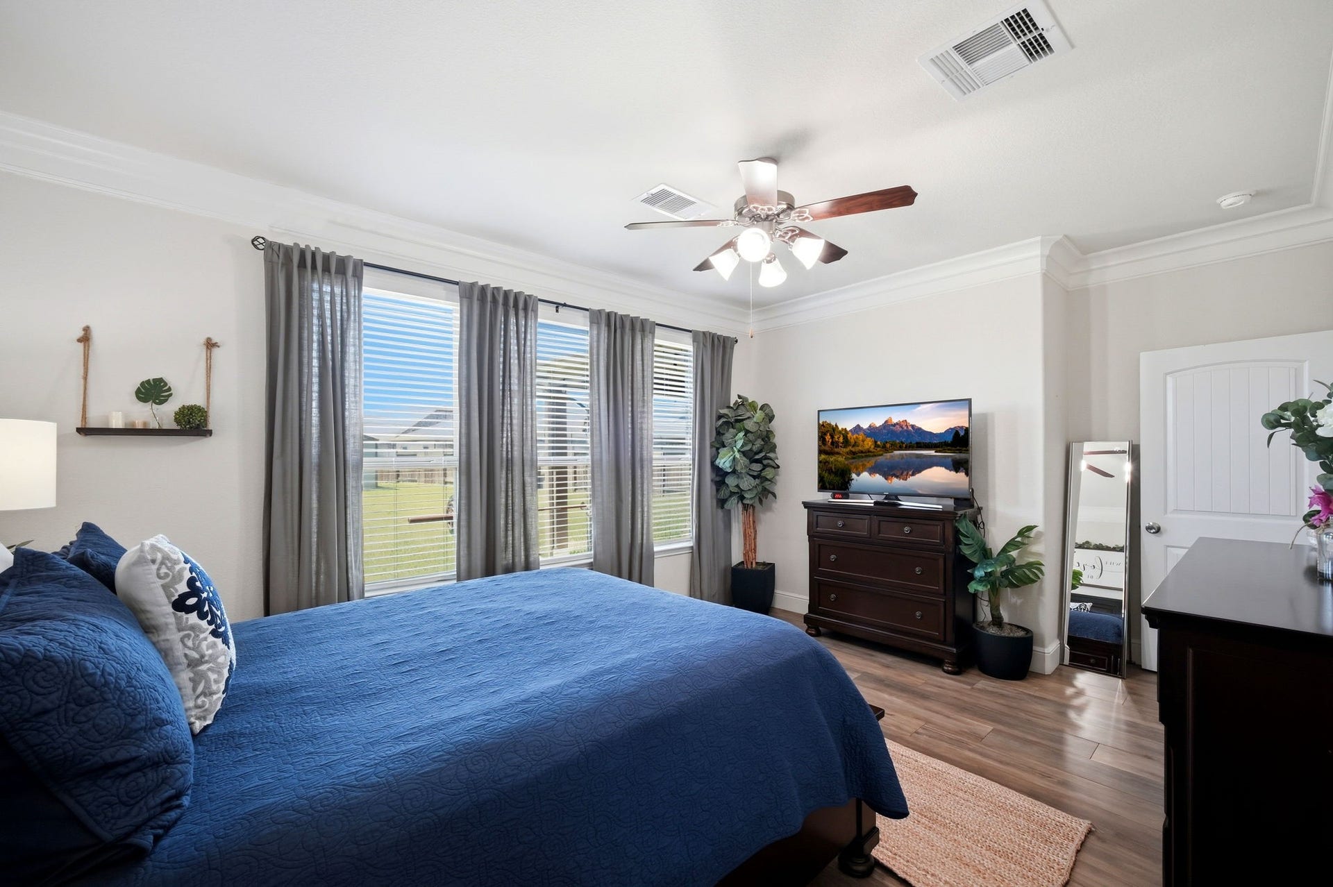 21639 Lexor Drive, Porter, TX 77365 Bright and inviting Primary bedroom featuring large windows with serene views, elegant flooring, and a ceiling fan for comfort.