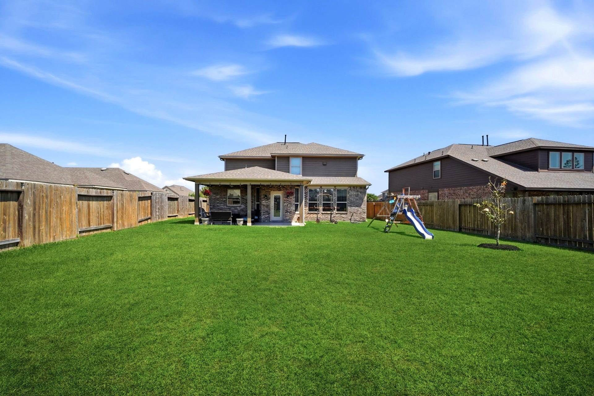 21639 Lexor Drive, Porter, TX 77365 Spacious backyard featuring lush green lawn, a cozy covered patio, perfect for family gatherings and outdoor fun.