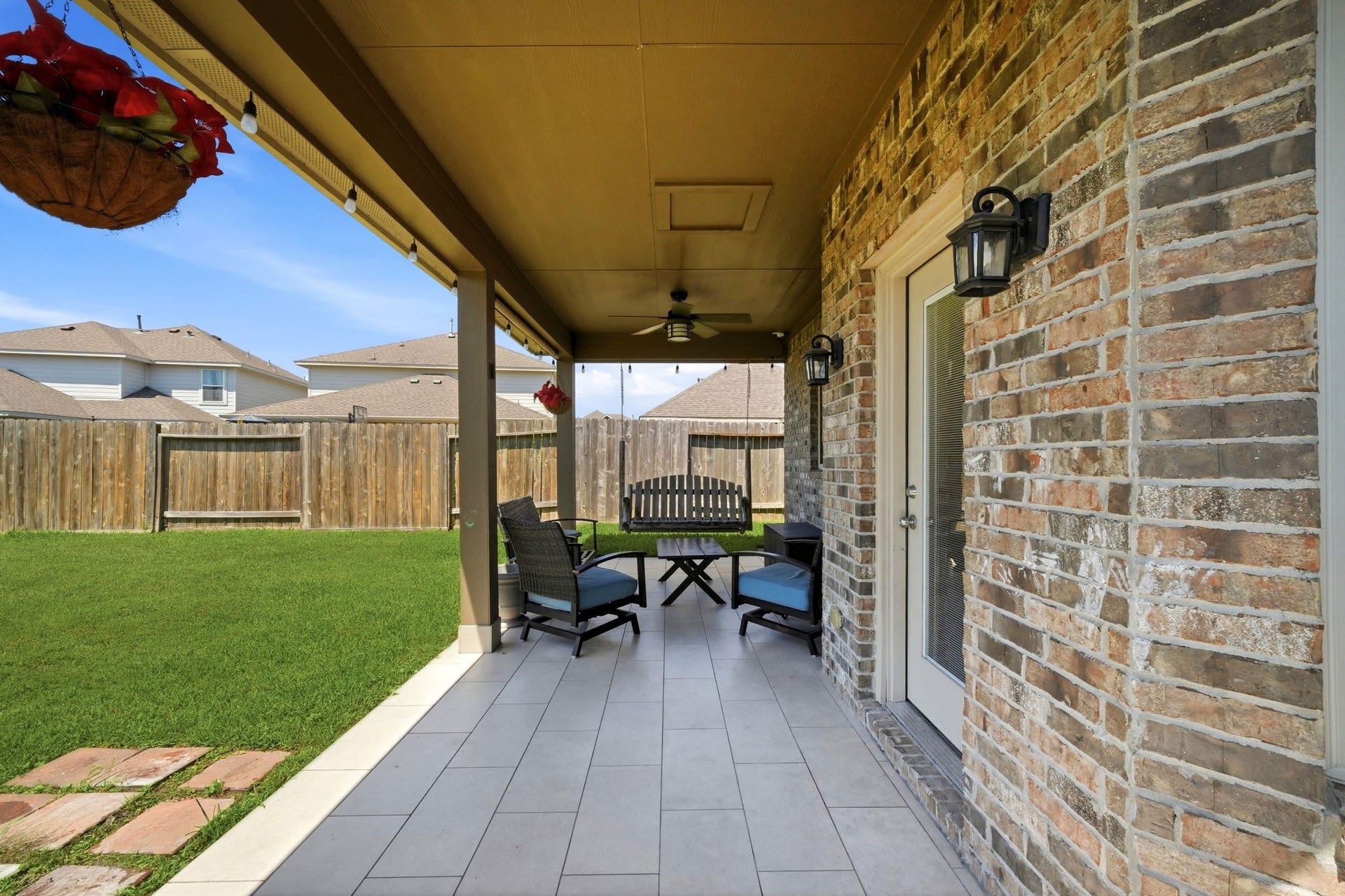 21639 Lexor Drive, Porter, TX 77365 Charming covered patio with stylish tile flooring, cozy seating, and a ceiling fan, perfect for relaxing and entertaining in a private fenced yard.