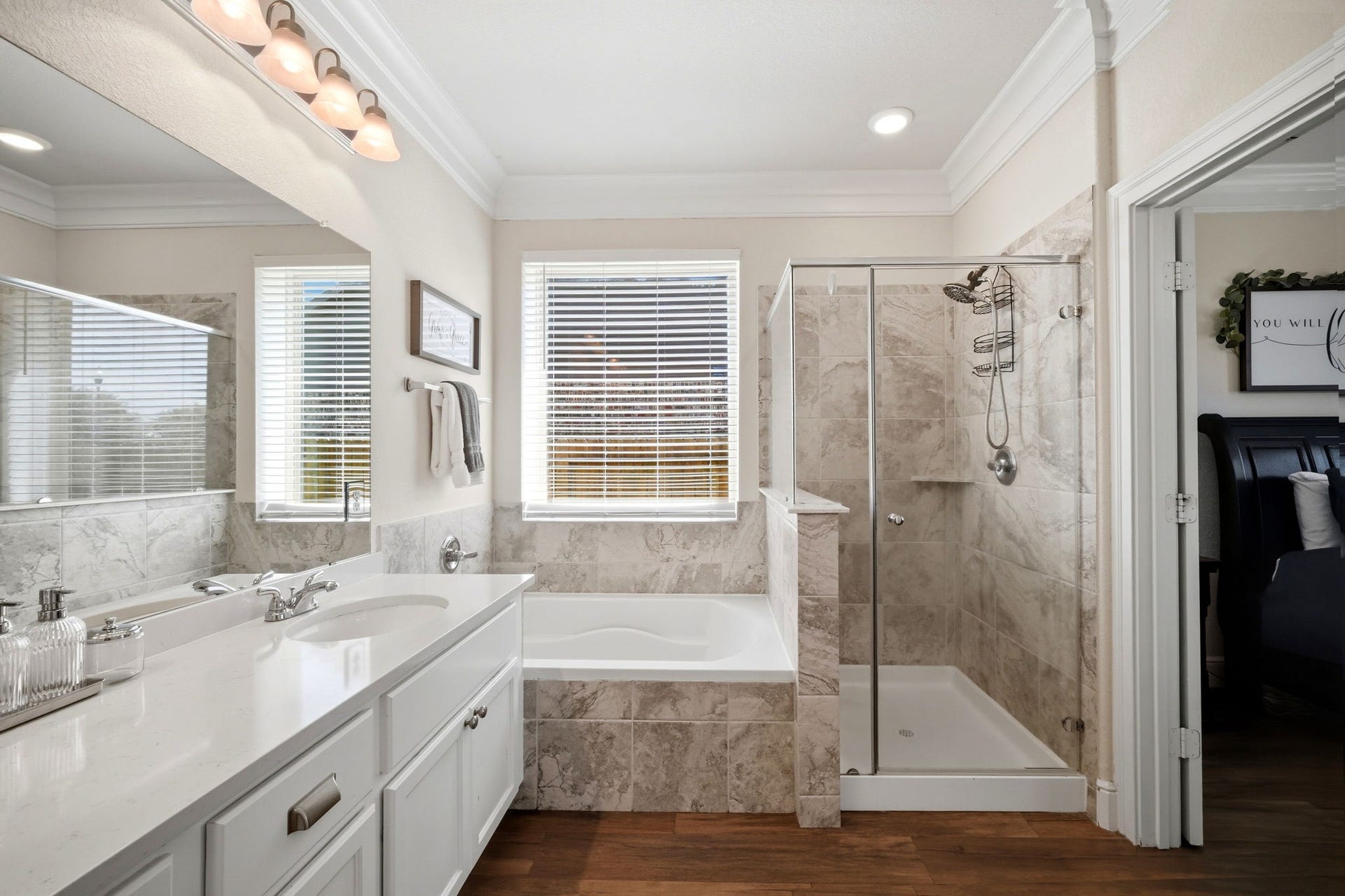 21639 Lexor Drive, Porter, TX 77365 Elegant bathroom with dual sinks, a luxurious soaking tub, and a modern glass-enclosed shower, complemented by stylish tilework and natural light.