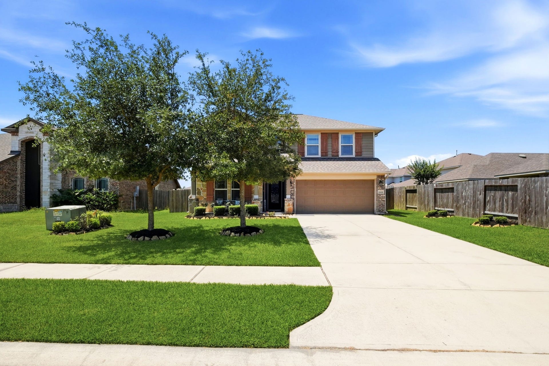 21639 Lexor Drive, Porter, TX 77365 Charming two-story home with a spacious driveway, lush front lawn, and mature trees offering ample shade.