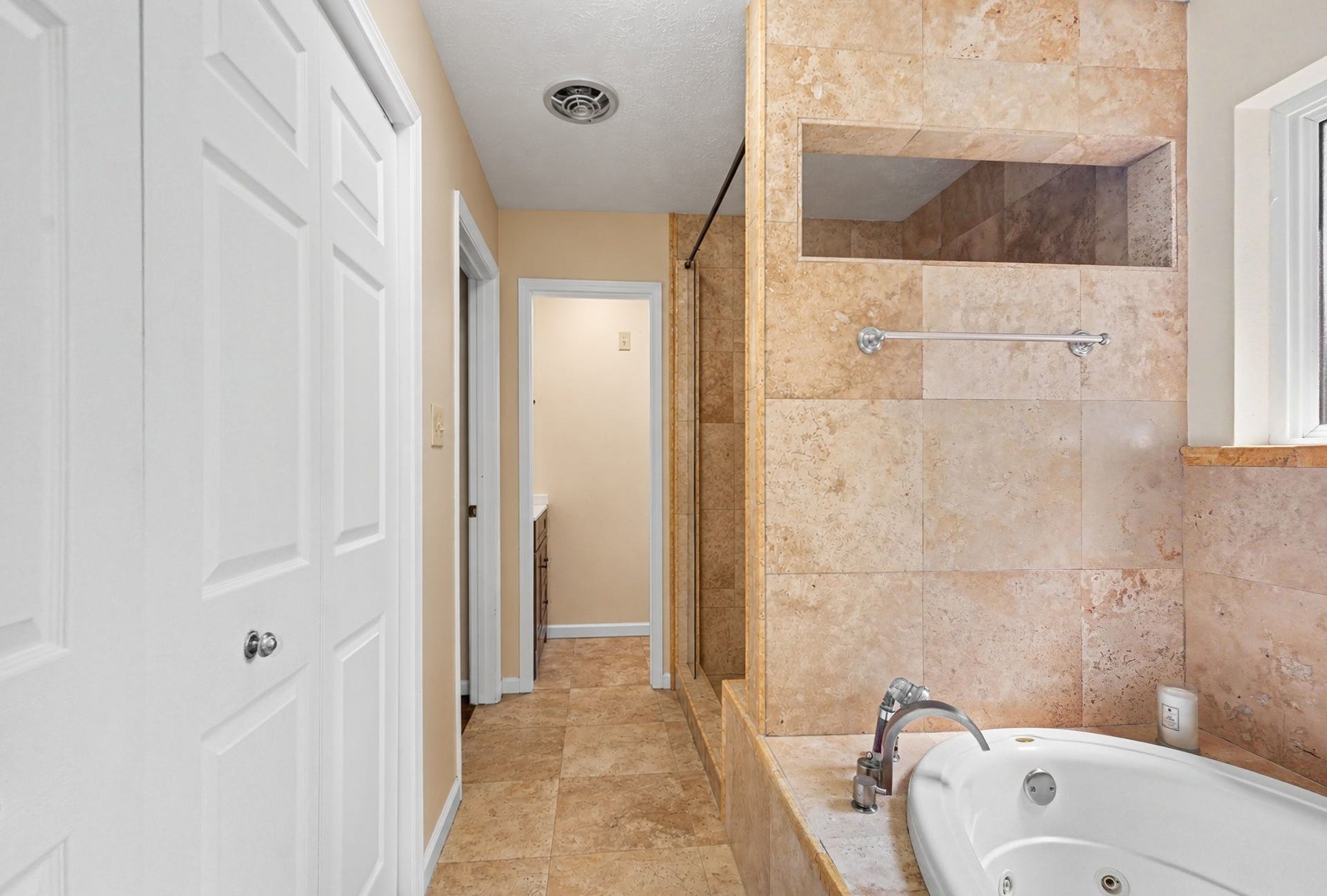 24609 Willow Lane, Hockley, TX 77447 Spacious en-suite primary bath featuring a jetted soaking tub, extensive tilework, and a separate walk-in shower. With access to the Laundry Room.