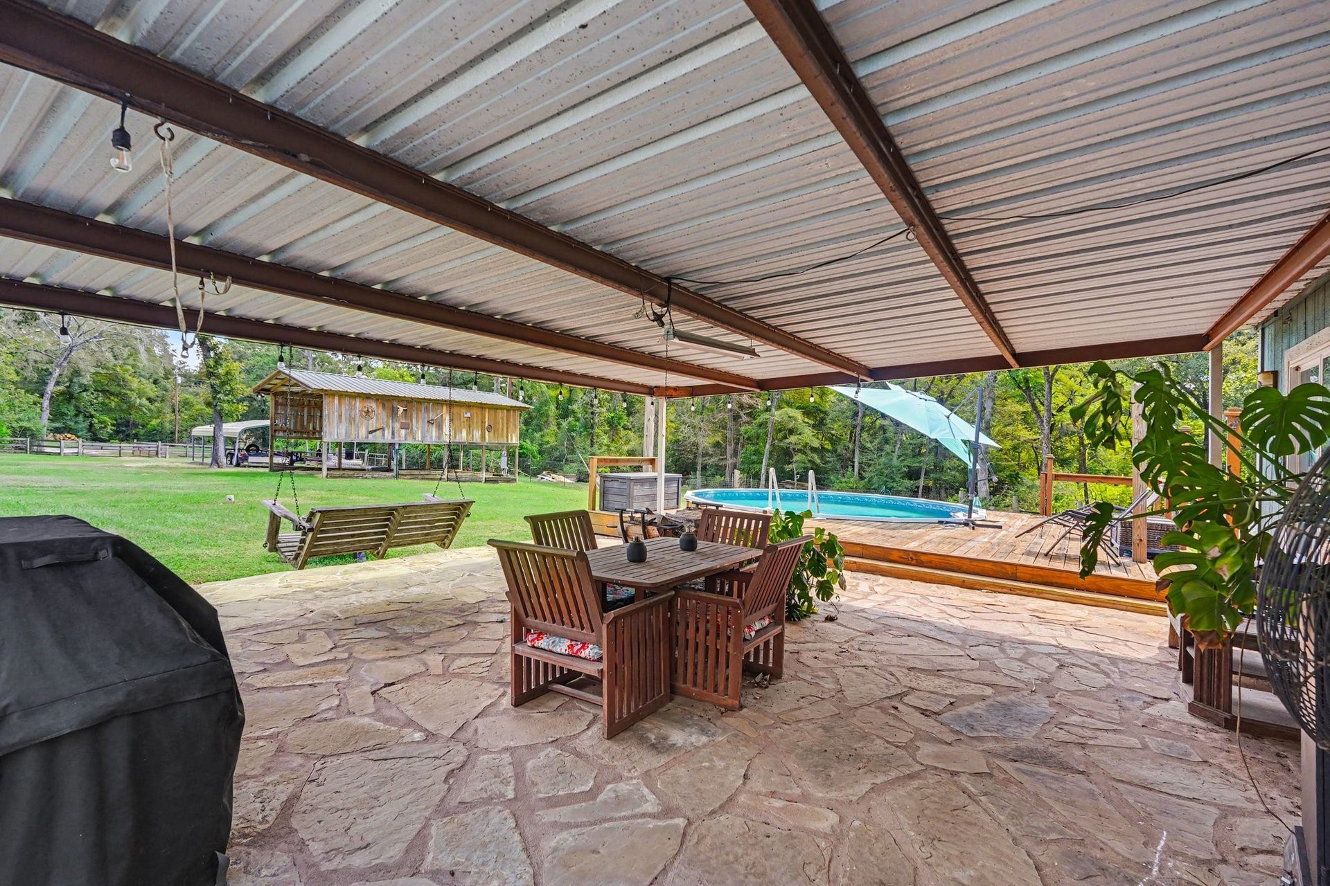 24609 Willow Lane, Hockley, TX 77447 Expansive covered patio with stone flooring overlooking the pool and large front yardan ideal setting for outdoor dining and entertaining.