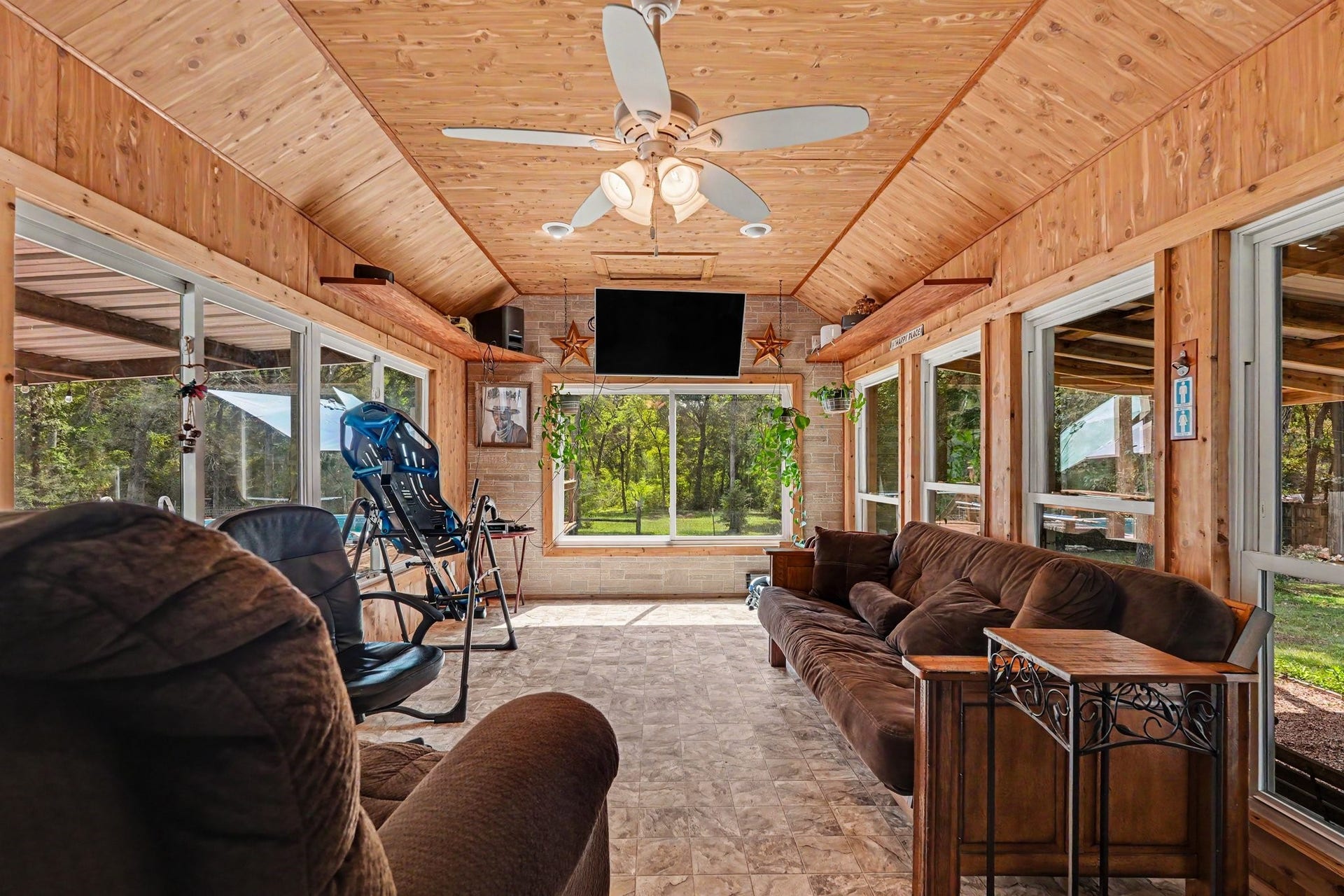 24609 Willow Lane, Hockley, TX 77447 Spacious enclosed sunroom surrounded by windows, featuring warm cedar wood finishes and plenty of room for relaxing or entertaining.