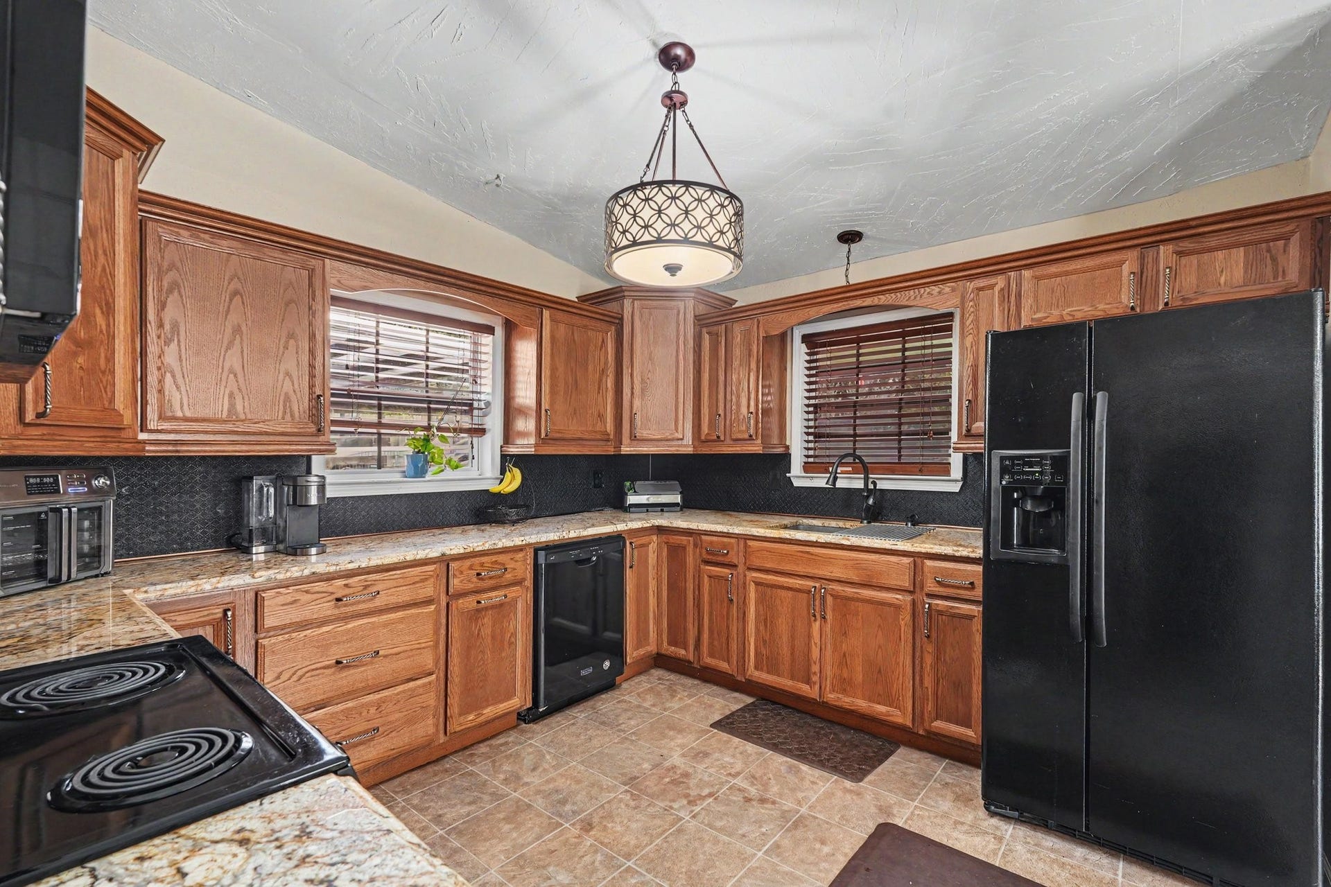 24609 Willow Lane, Hockley, TX 77447 Another view of the kitchen showcasing extensive cabinet storage, ample countertops, and windows bringing in natural light.