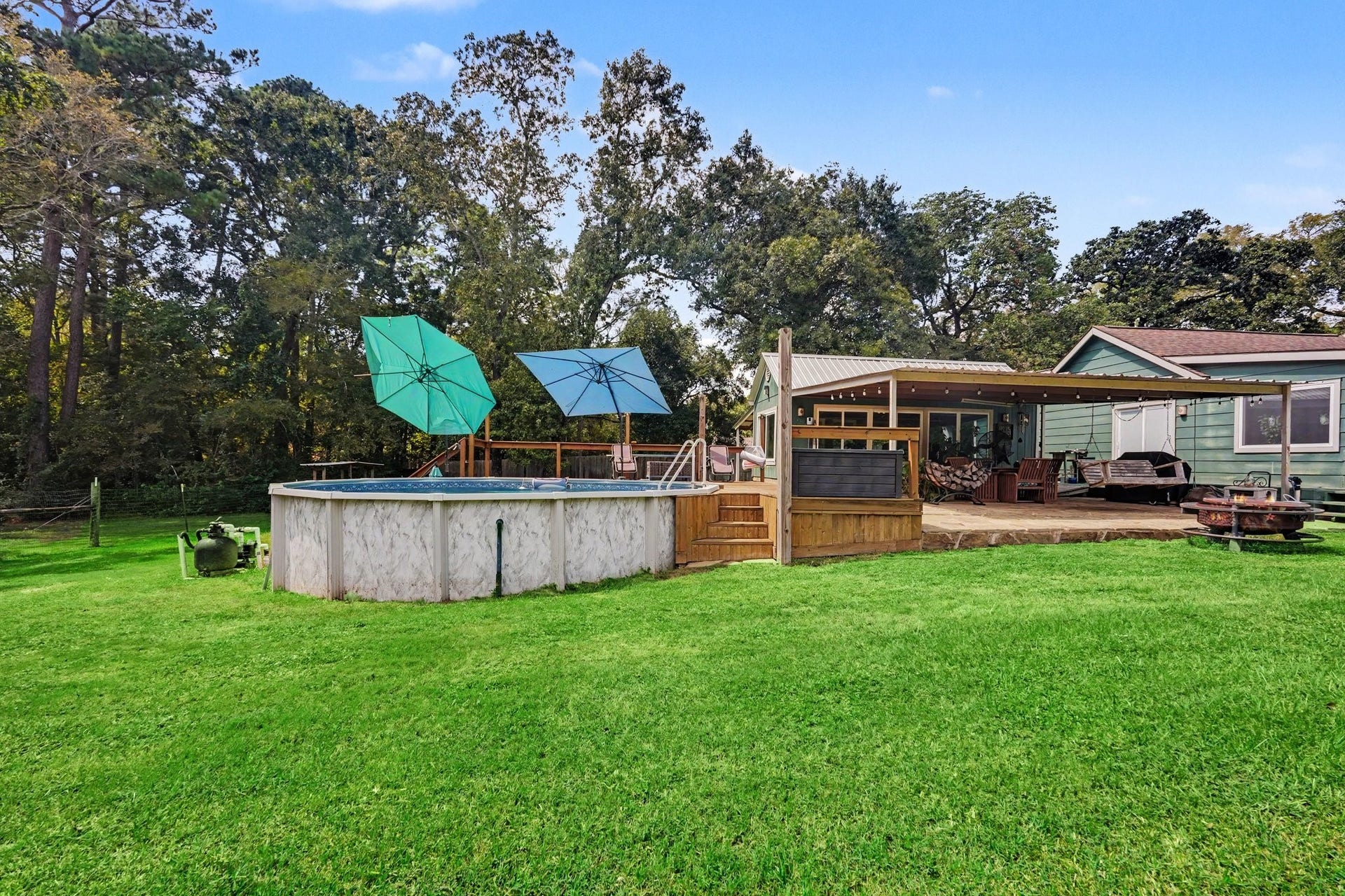 24609 Willow Lane, Hockley, TX 77447 Wide view of the front yard highlighting the above-ground pool, deck, covered patio, and generous lawn.