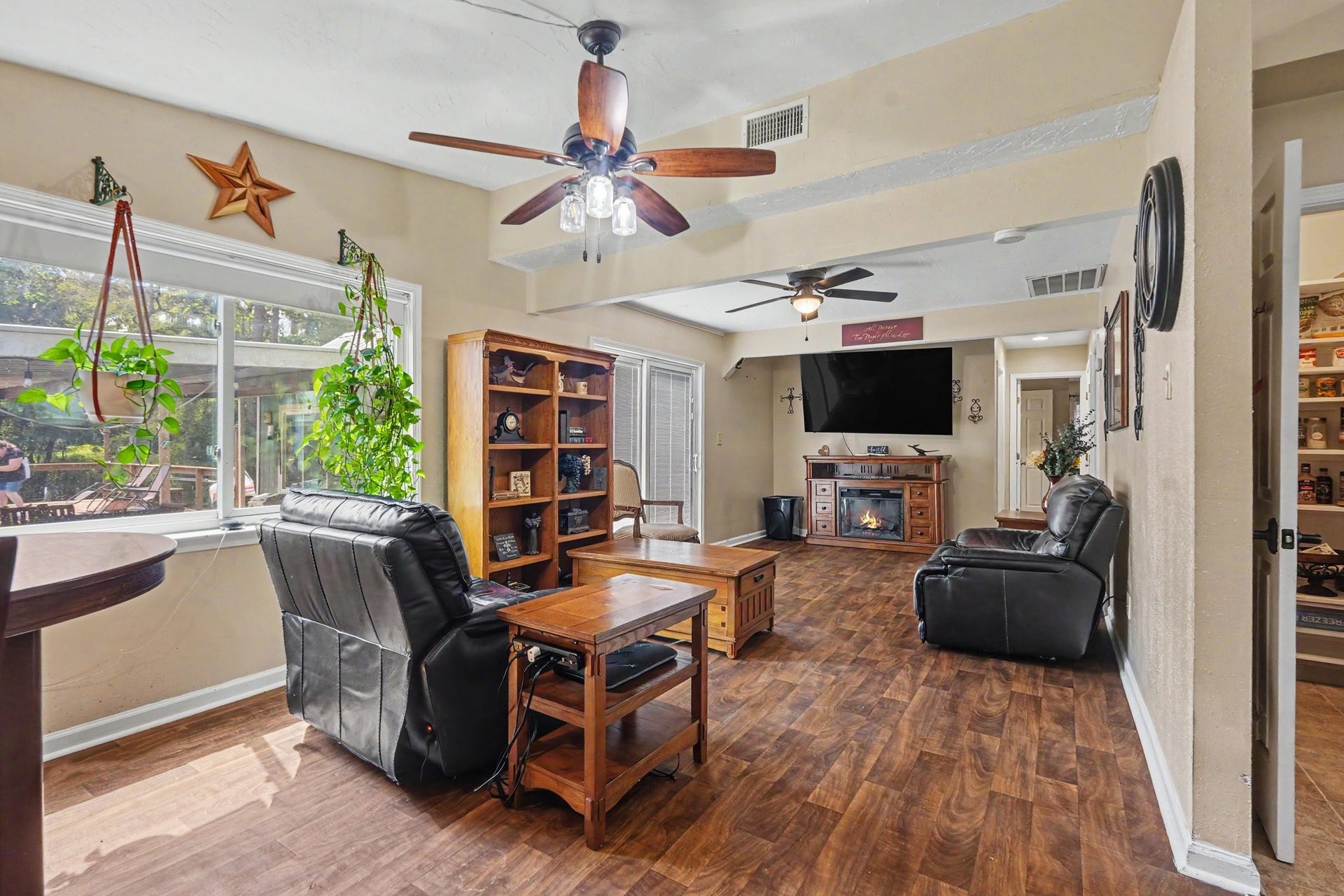 24609 Willow Lane, Hockley, TX 77447 Spacious living area with warm wood-look flooring, abundant natural light, and an open layout that flows into the dining area.