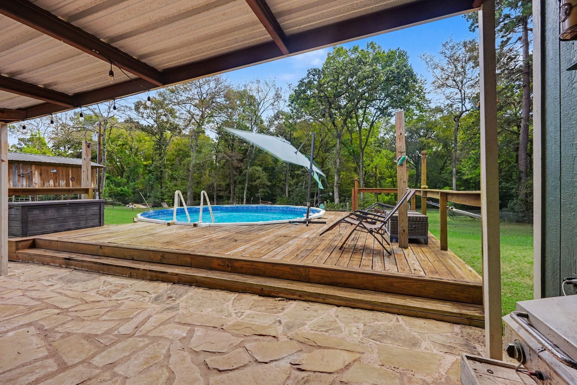 24609 Willow Lane, Hockley, TX 77447 Above-ground pool surrounded by a spacious wood deck with room for lounging and easy access from the covered patio.