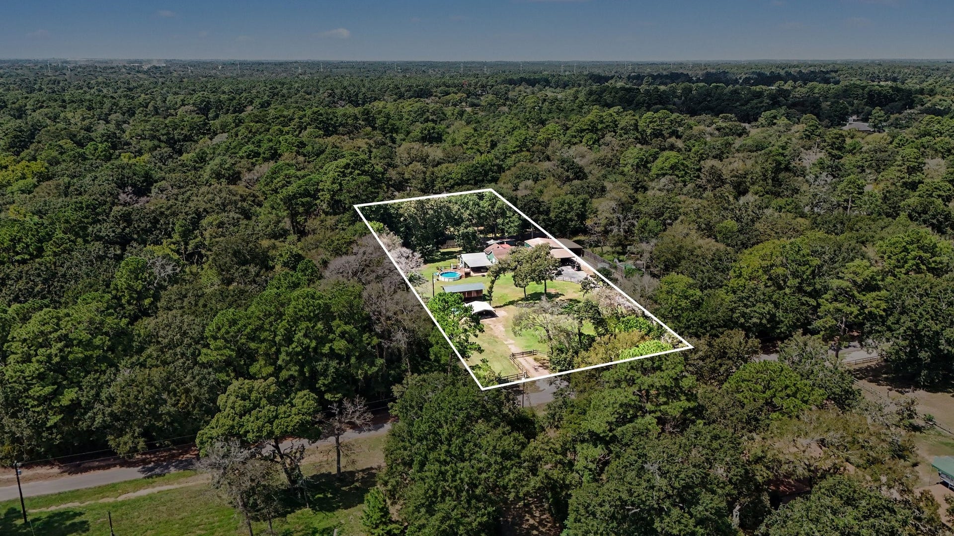 24609 Willow Lane, Hockley, TX 77447 Welcome to Clear Creek Forest. This aerial view highlights the propertys spacious acreage, mature trees, and peaceful setting surrounded by the natural beauty of this established Hockley community.