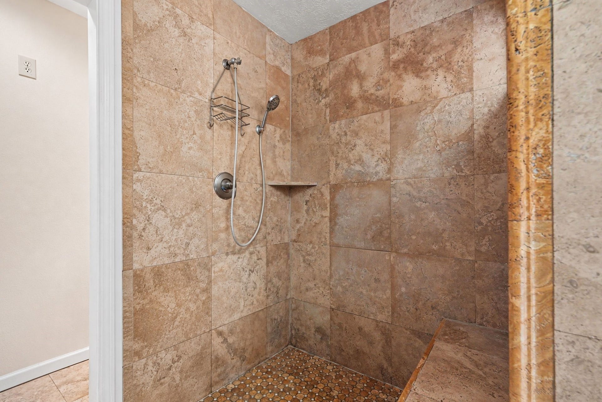 24609 Willow Lane, Hockley, TX 77447 Large tiled walk-in shower with handheld showerhead, built-in bench, and convenient corner shelf.