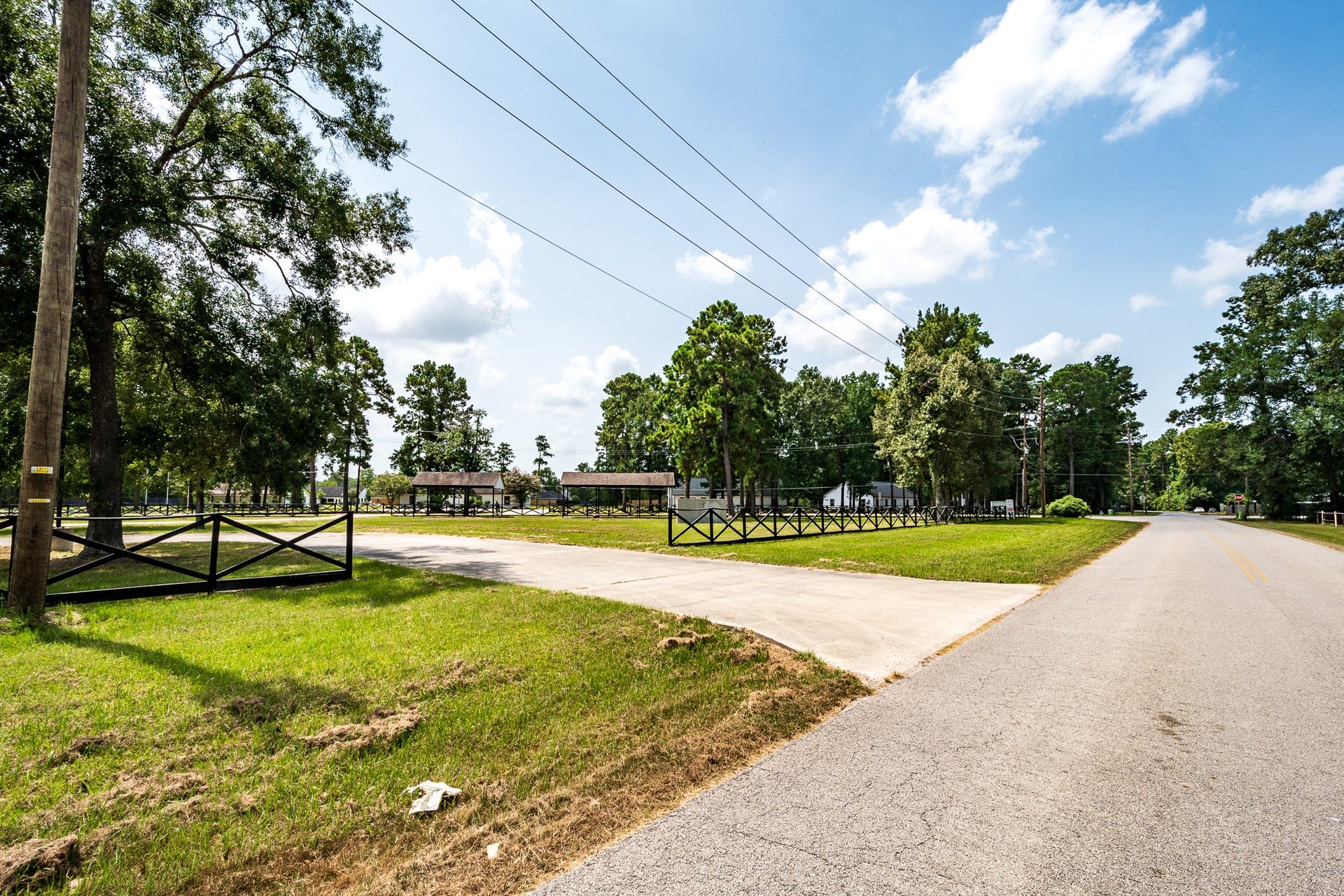 16111 Porter Lane, Porter, TX 77365 Expansive lot with a charming fence and mature trees, offering a serene setting along a quiet road.