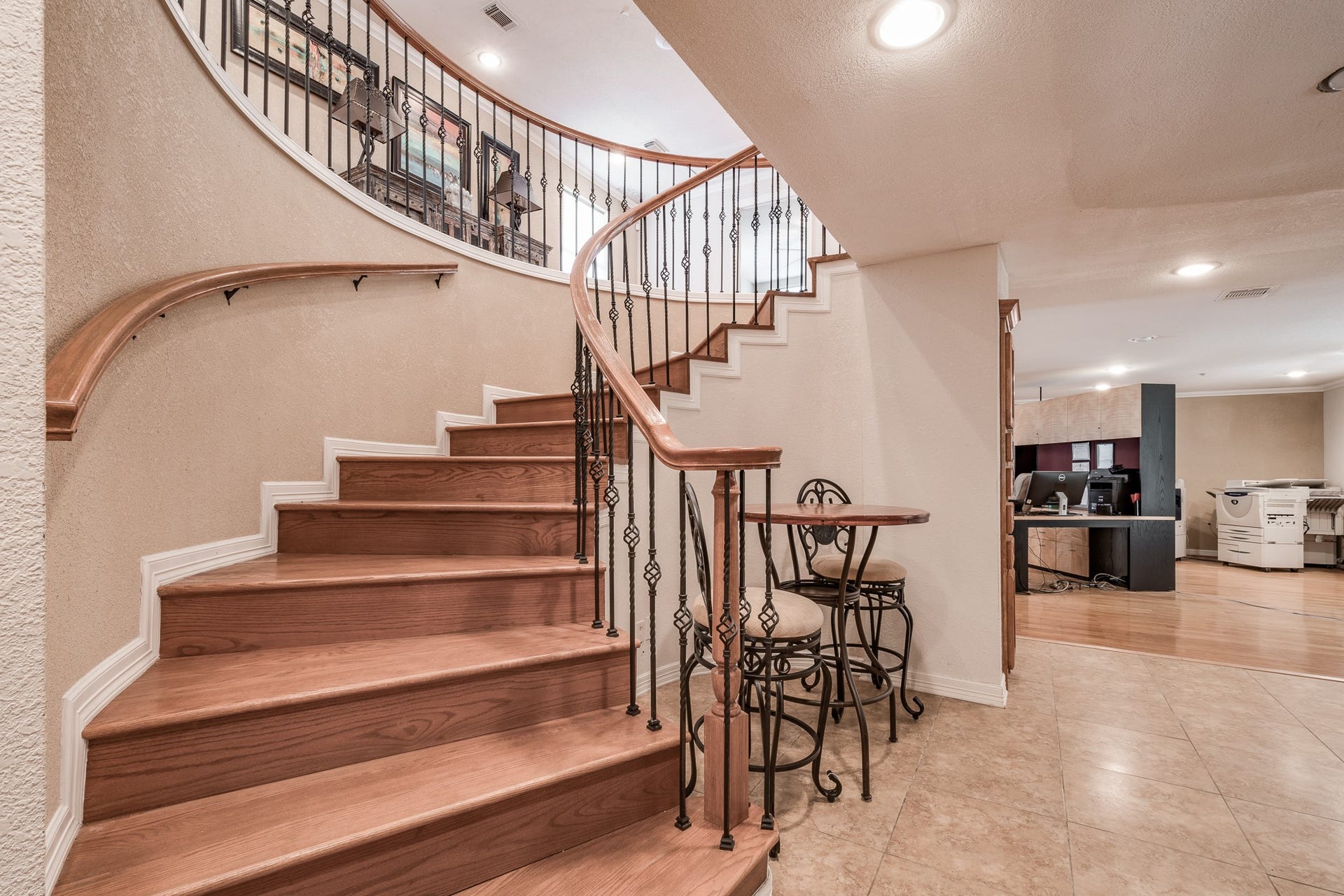 16111 Porter Lane, Porter, TX 77365 Elegant curved staircase with wood steps and wrought-iron railing, leading to an open upper level. Adjacent nook features a charming bistro set, complementing the spacious and inviting floor plan.