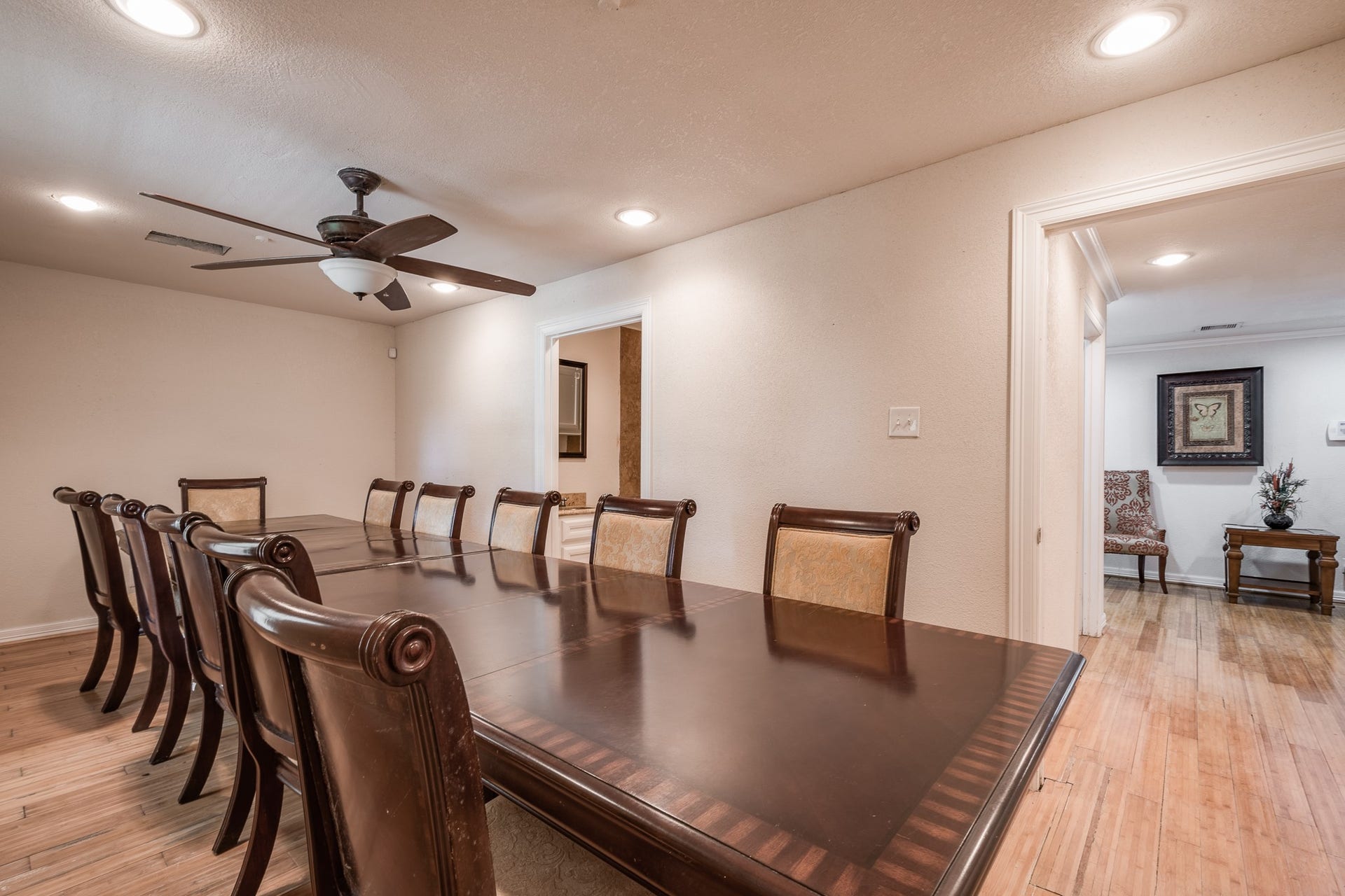 16111 Porter Lane, Porter, TX 77365 Elegant dining room with a spacious table for ten, highlighted by warm wood flooring and recessed lighting, perfect for gatherings.