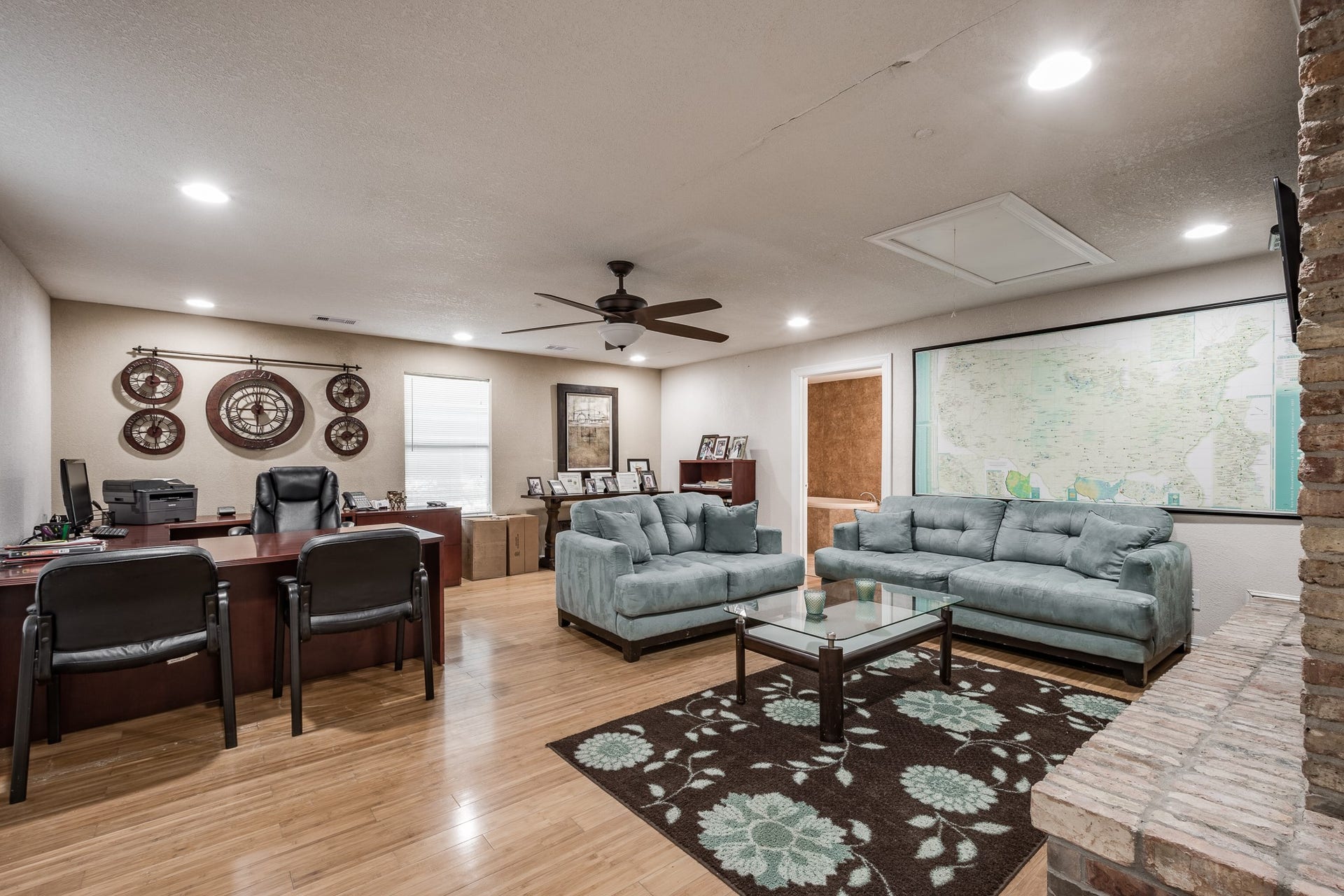16111 Porter Lane, Porter, TX 77365 Spacious home office featuring a large desk, comfortable seating area with plush sofas, and elegant wood flooring, perfect for productivity and relaxation.