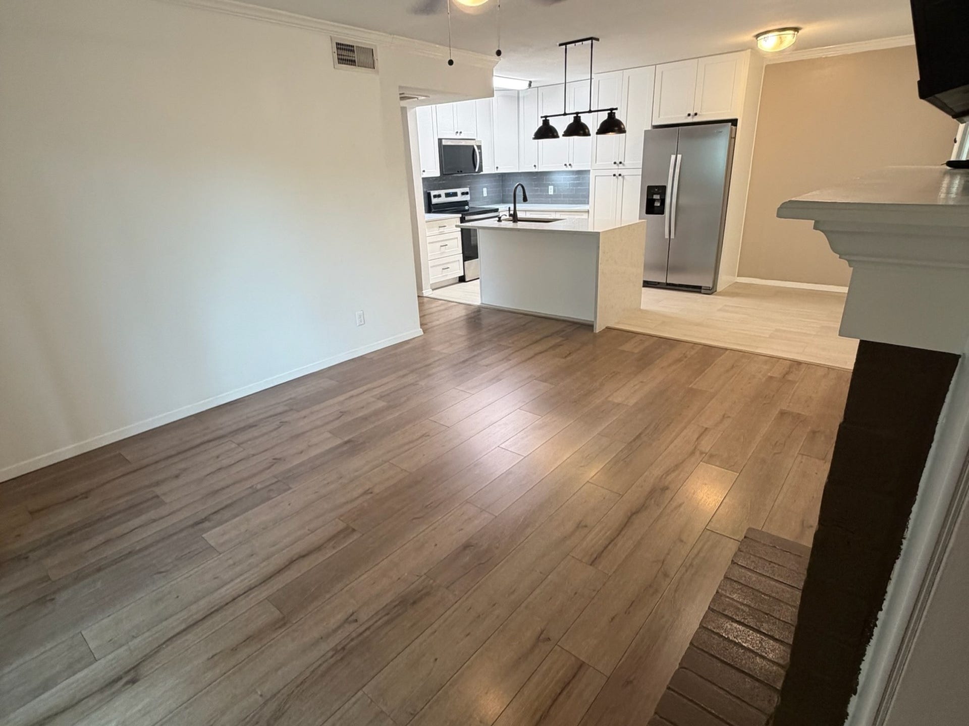 3500 Tangle Brush Drive, #65, The Woodlands, TX 77381 Spacious living area offers plenty of flexibility for furniture placement, with warm wood-look flooring and an open sightline to the beautifully updated kitchen and dining space.