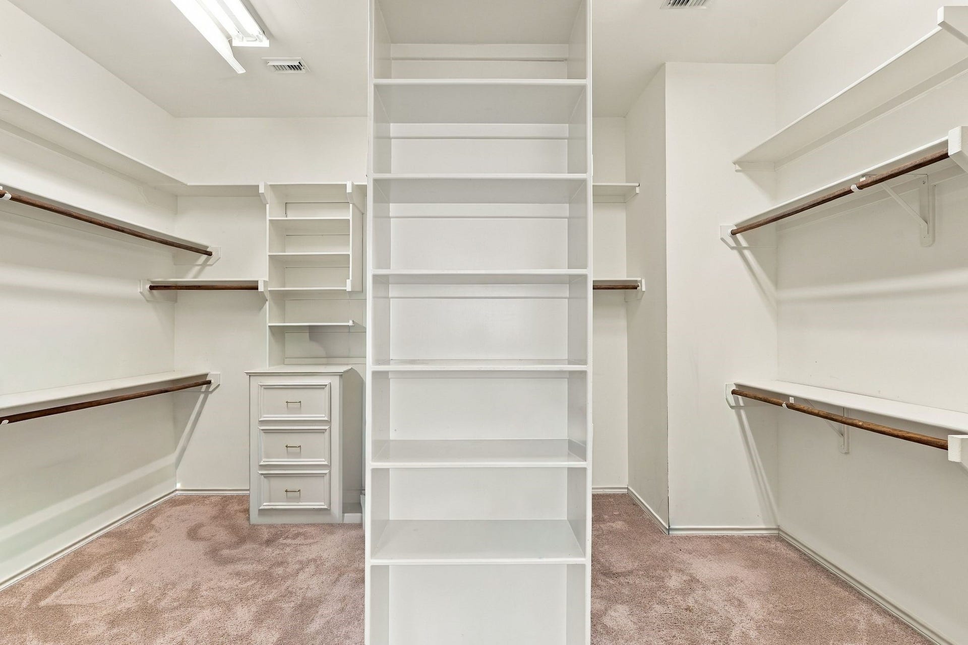 299 Wedgewood Drive, Montgomery, TX 77356 Spacious primary bedroom closet featuring custom built-in shelving and storage solutions.