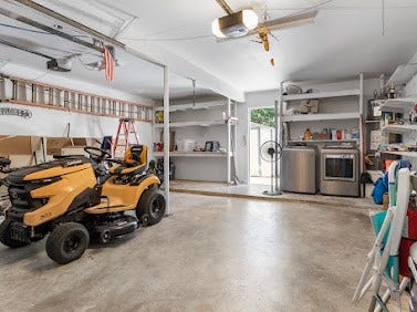 16606 Oxnard Lane, Friendswood, TX 77546 Spacious two-car garage featuring built-in shelving for additional storage and a convenient laundry area.
