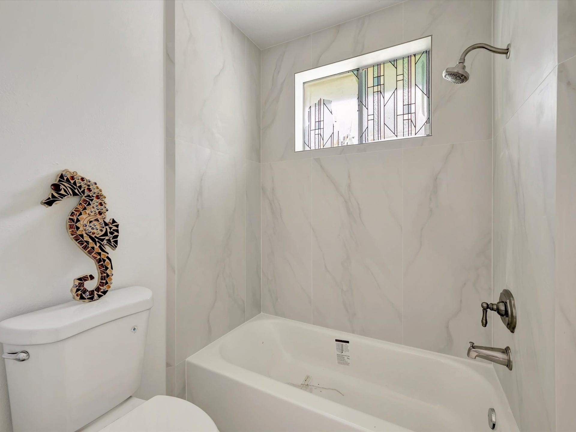 1003 Richvale Lane, Houston, TX 77062 Guest bath with new tub and shower surrounded with porcelain tiles.