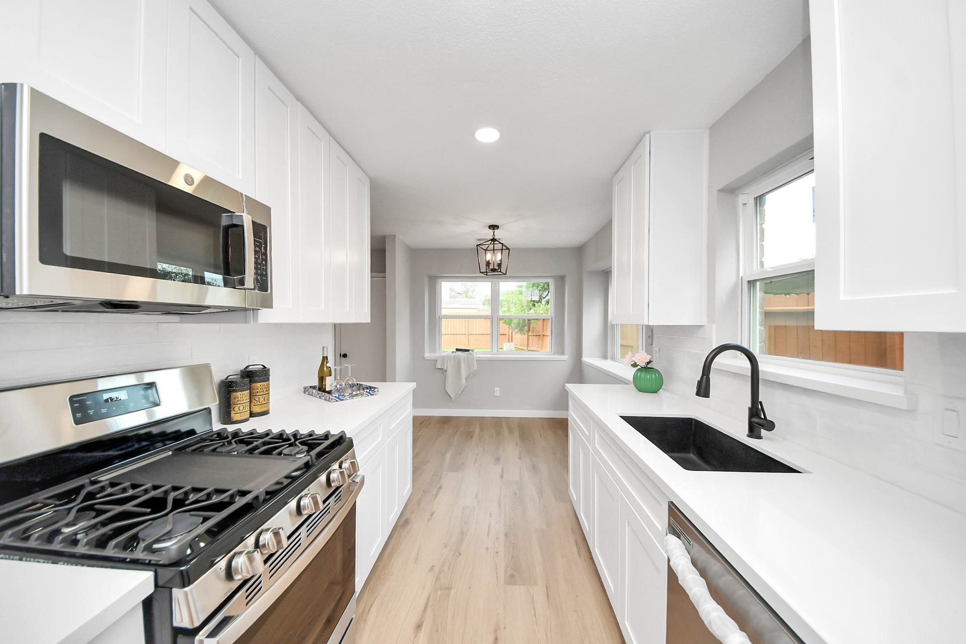 3234 Pebble Lake Drive, Sugar Land, TX 77479 This bright kitchen features modern stainless steel appliances, sleek white cabinetry, and elegant countertops. The open layout is complemented by natural light from the window, creating an inviting space.