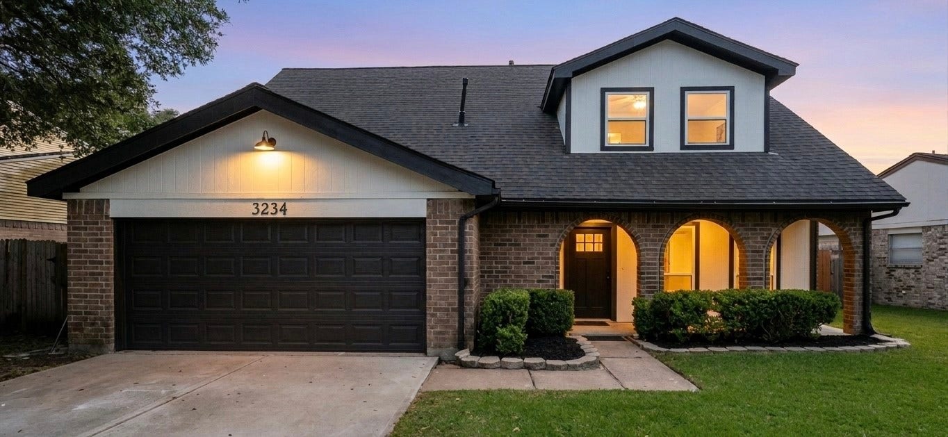 3234 Pebble Lake Drive, Sugar Land, TX 77479 This charming two-story home features a classic brick exterior with arched entryways, a spacious two-car garage, and a well-maintained front lawn. The warm lighting enhances its inviting appearance.