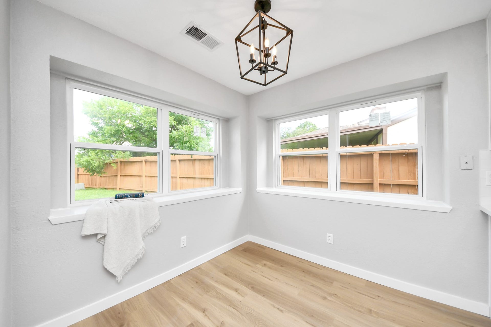 3234 Pebble Lake Drive, Sugar Land, TX 77479 Bright, cozy room with large windows offering plenty of natural light. Features light wood flooring and a modern hanging light fixture, perfect for a small dining area or reading nook.
