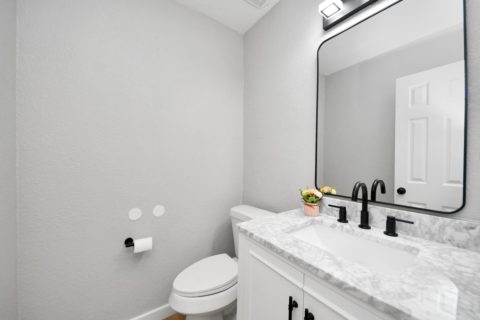 3234 Pebble Lake Drive, Sugar Land, TX 77479 This is a modern bathroom with a sleek design featuring a marble countertop, black fixtures, and a large mirror. The space is bright and well-organized, adding a touch of elegance.