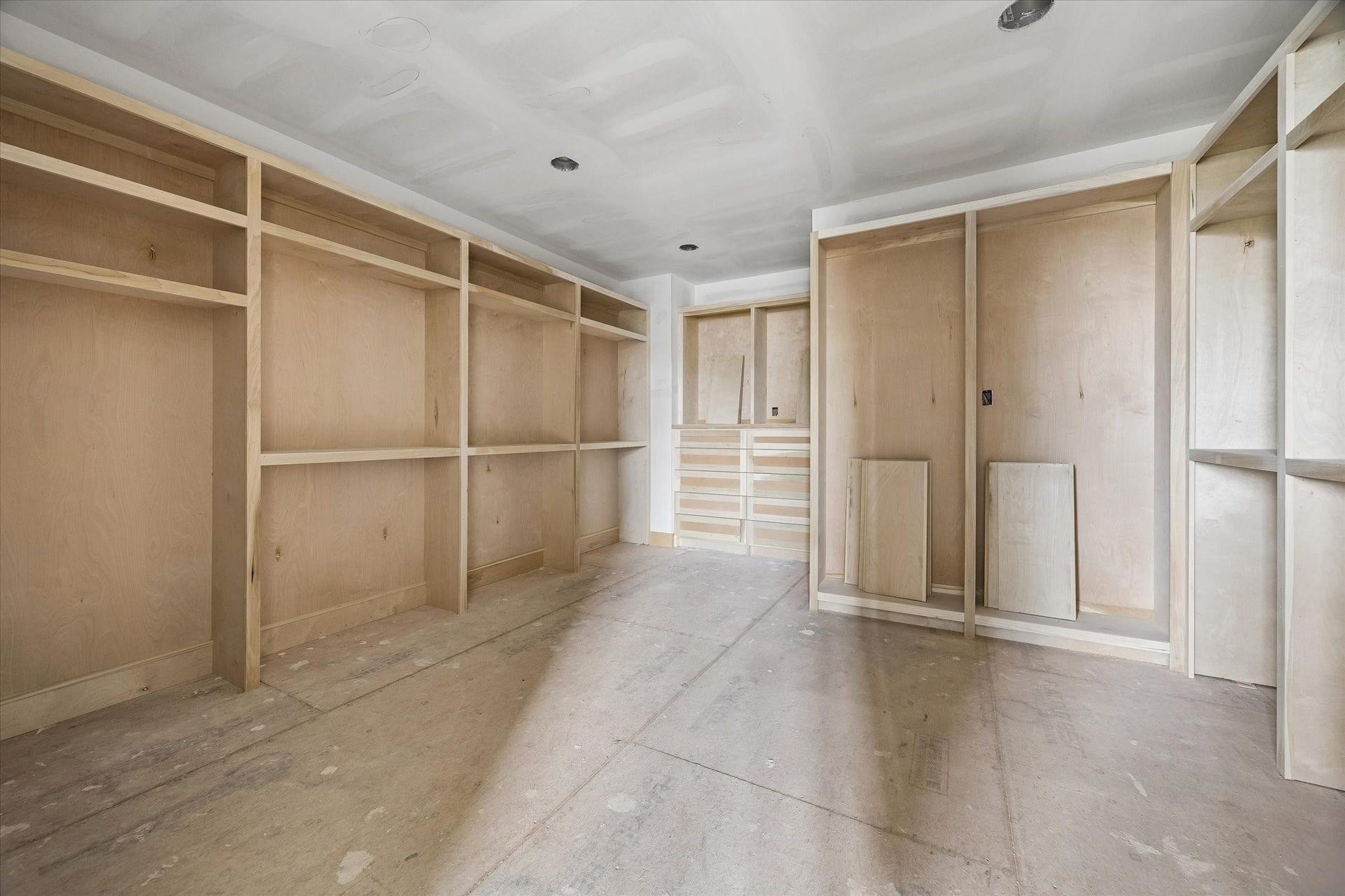 An oversized primary closet is thoughtfully designed with extensive custom built ins, dedicated hanging sections, open shelving and drawer storage. The generous layout creates a true dressing room experience with space to keep everything beautifully organized. **Current Construction as of 9/11/26
