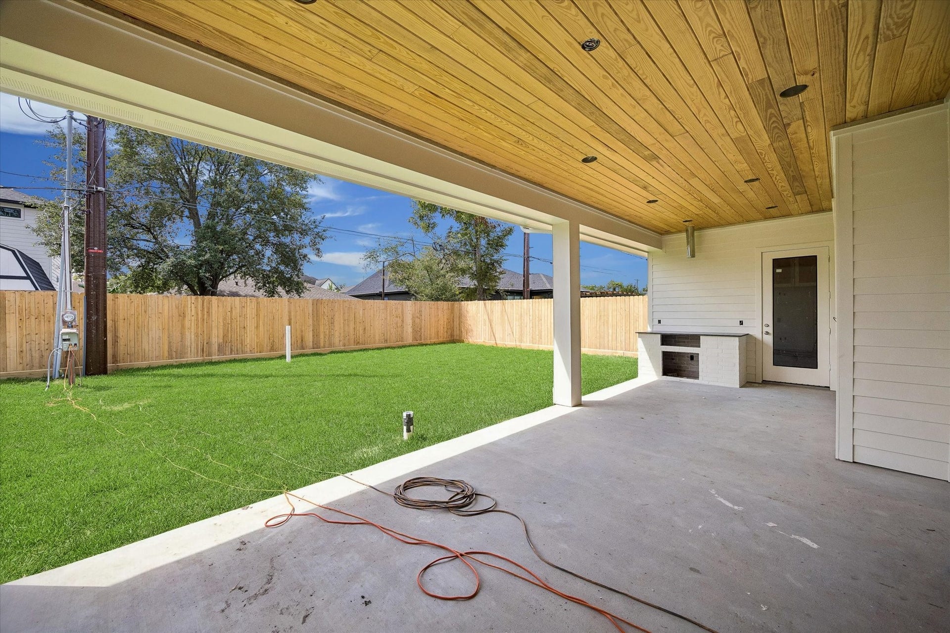 Covered outdoor living is elevated with a warm wood plank ceiling, recessed lighting, and a built in grilling station. Generous proportions leave plenty of room for dining and lounging while overlooking the expansive backyard. **Current Construction as of 9/11/26