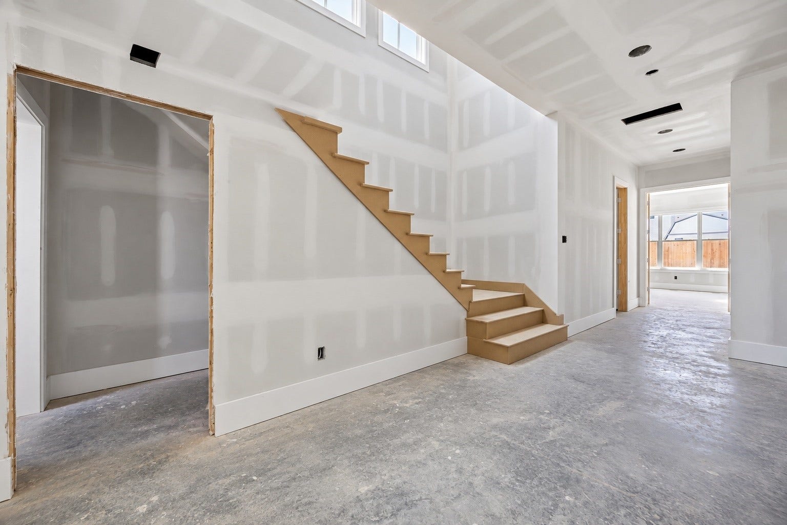 A light filled stair hall adds architectural interest with upper windows drawing natural light through the center of the home. The open layout maintains clear sightlines while creating a natural transition between the main living areas and private spaces beyond. **Current Construction as of 9/11/26