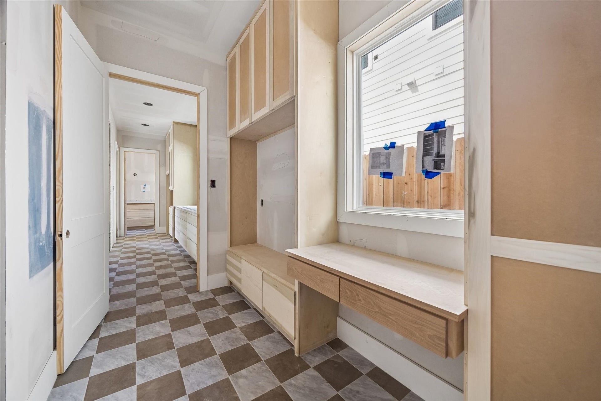 A thoughtfully designed mud room keeps everyday routines organized with custom built ins, generous cabinetry, and a dedicated drop zone. Checkerboard flooring adds character while a large window brings natural light into the space. **Current Construction as of 9/11/26