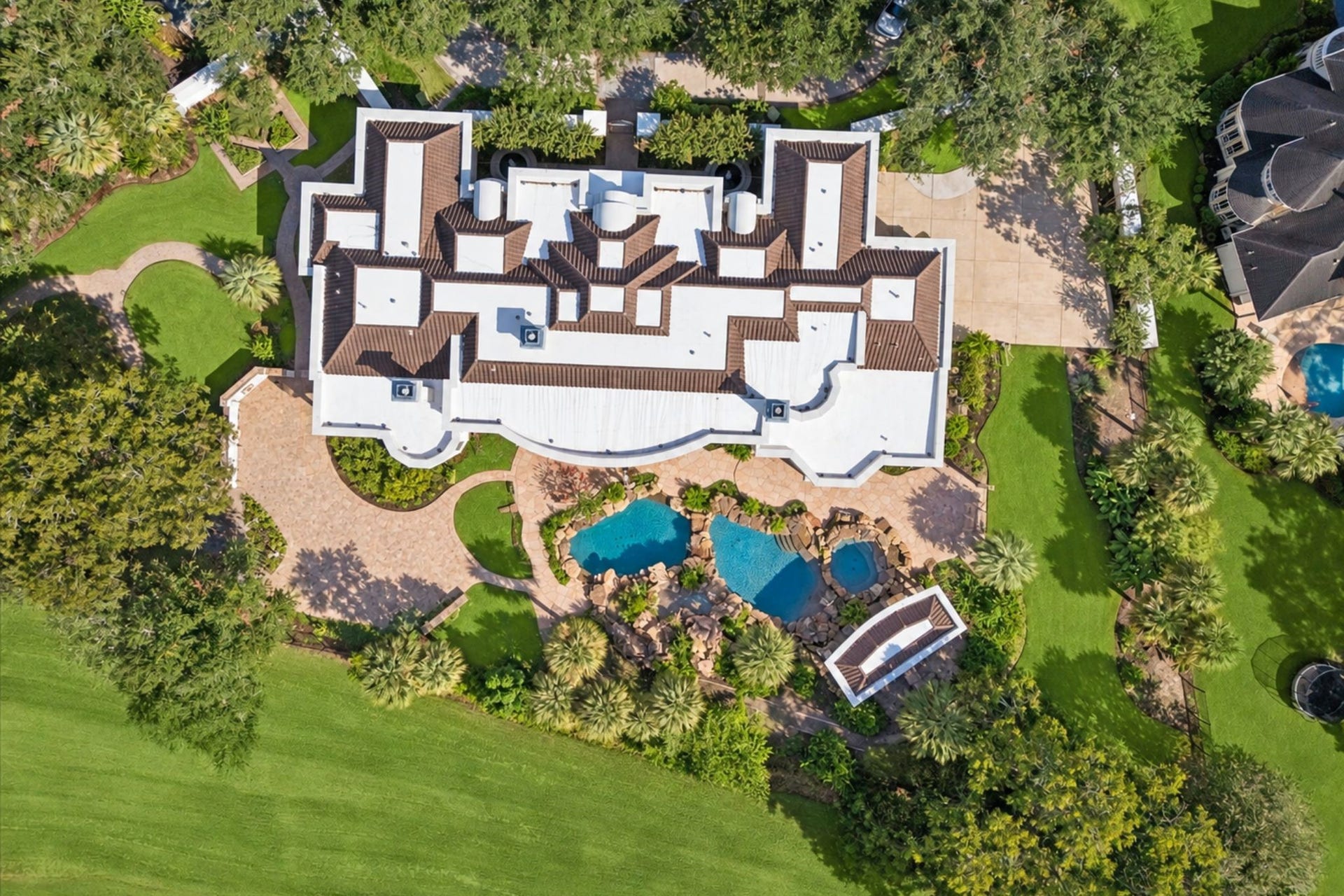 1822 FOREST GATE CIRCLE, Sugar Land, TX 77479 THE IMPRESSIVE REAR ELEVATION FEATURES MULTIPLE COVERED OUTDOOR AREAS, A RESORT-STYLE POOL, MATURE LANDSCAPING, AND BEAUTIFUL GOLF COURSE VIEWS.
