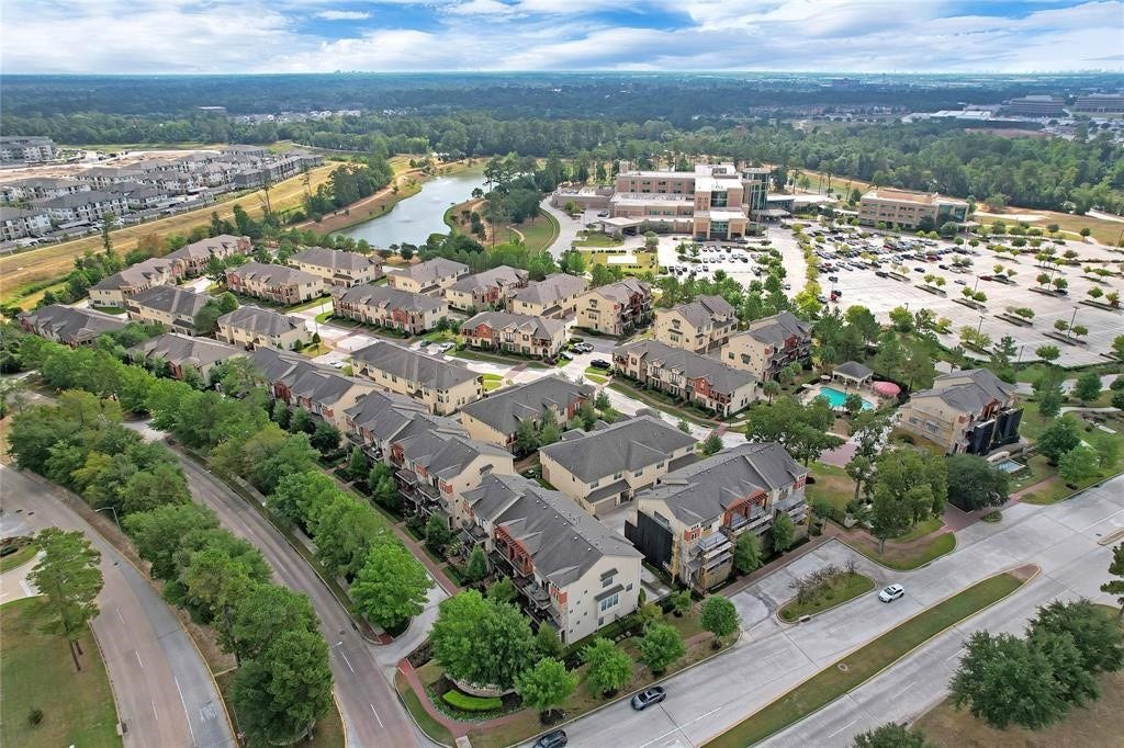 14502 San Pietro Drive, Houston, TX 77070 Charming townhome community nestled in a lush, green setting, featuring a picturesque lake and modern amenities nearby.